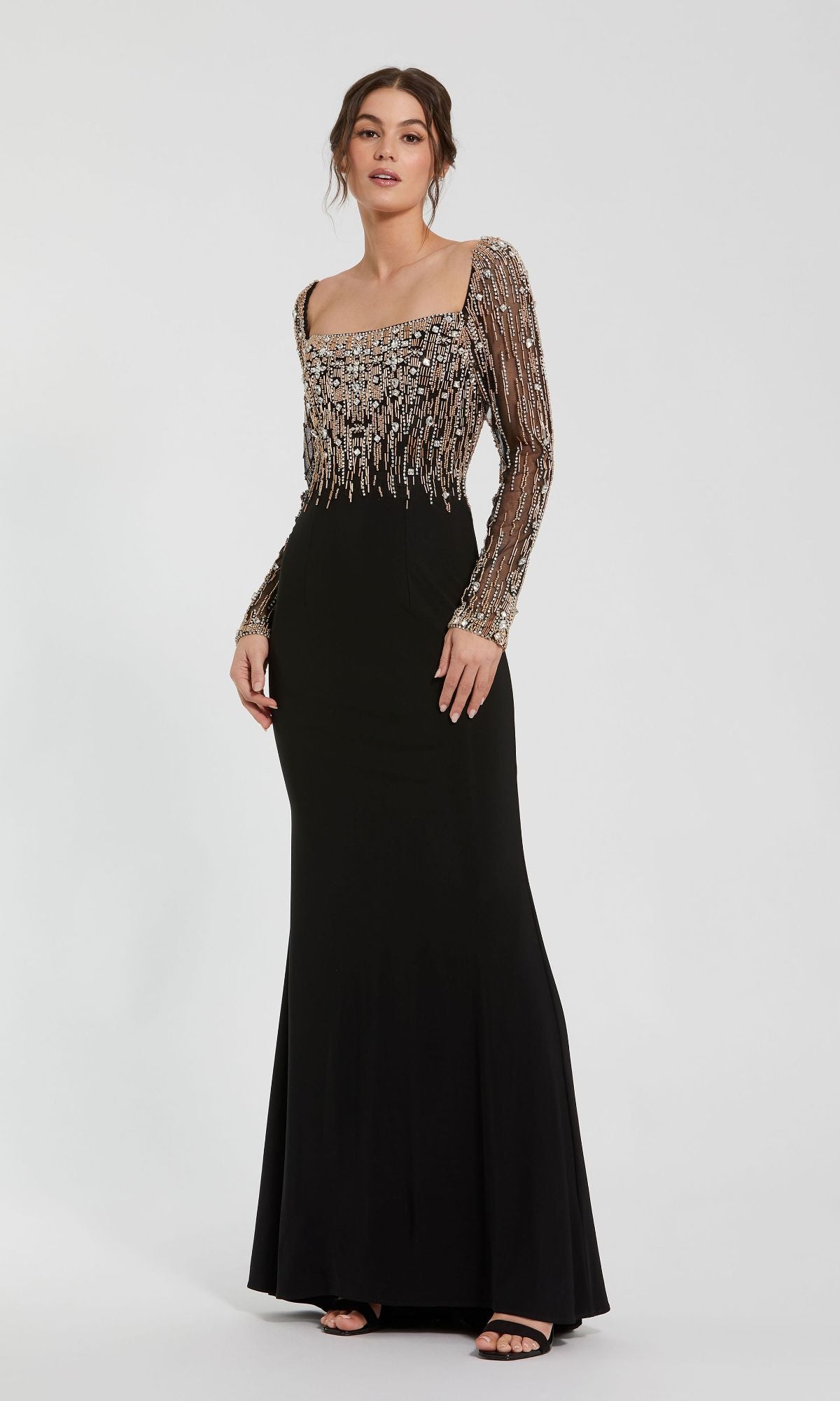 A woman wears the Mac Duggal 2256 Long Sleeve Long Formal Dress, featuring a square neckline and beaded metallic embellishments on the bodice and sleeves.