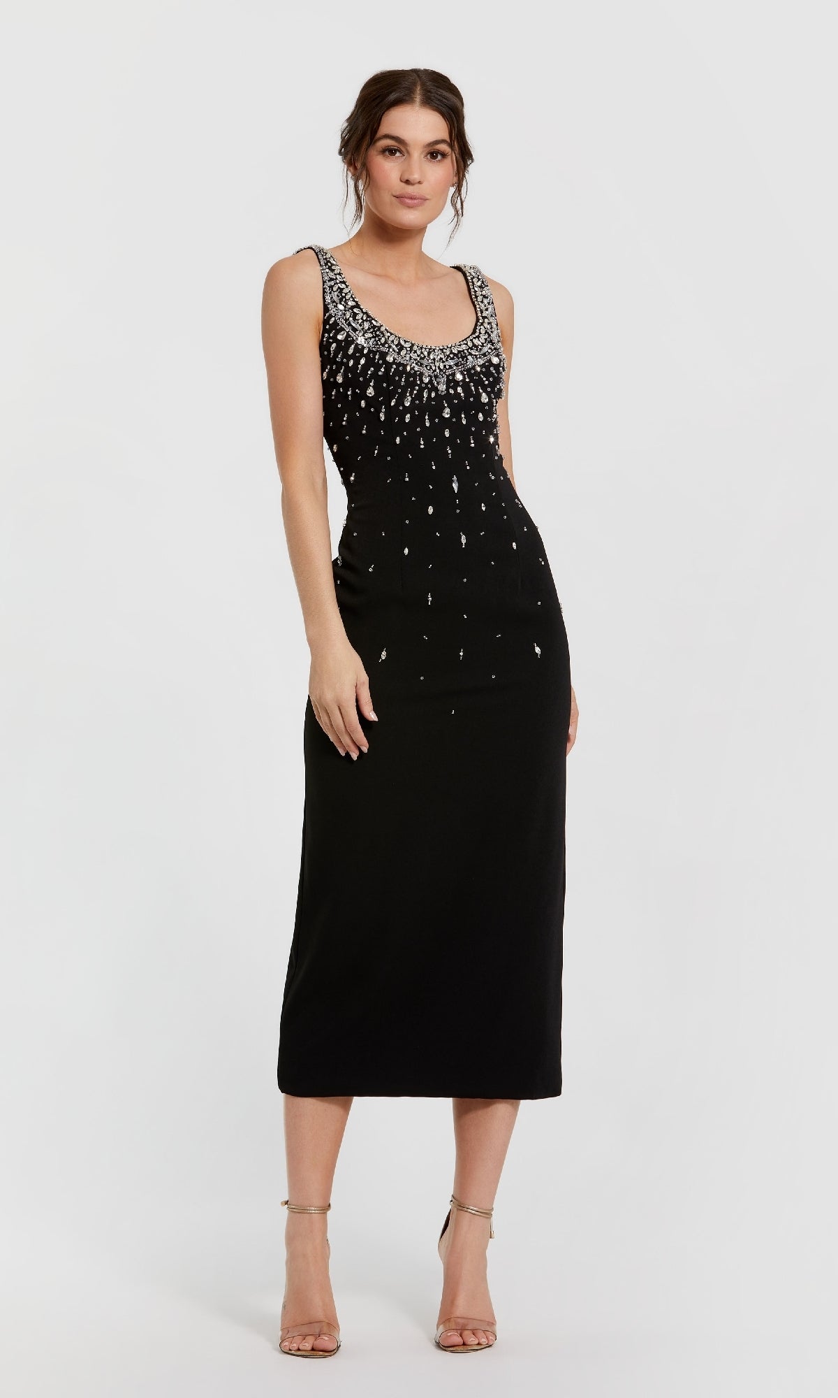 Woman wearing a black dress with silver embellishments on a white background