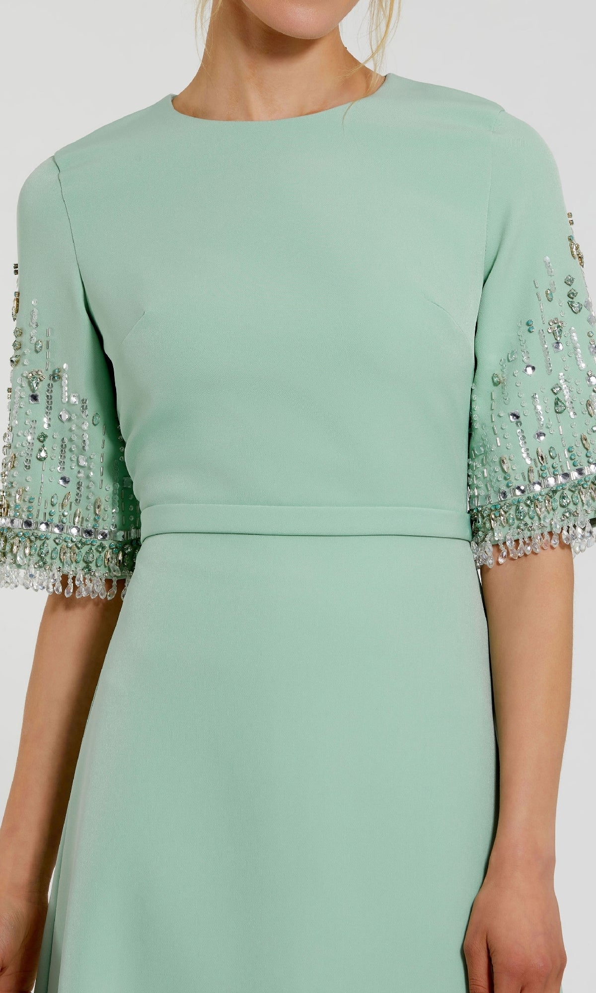 A woman wearing the Mac Duggal 2270 Short Sleeve Sleek Formal Dress in mint green, featuring beaded embellishments on the sleeves, shown from shoulders to knees.