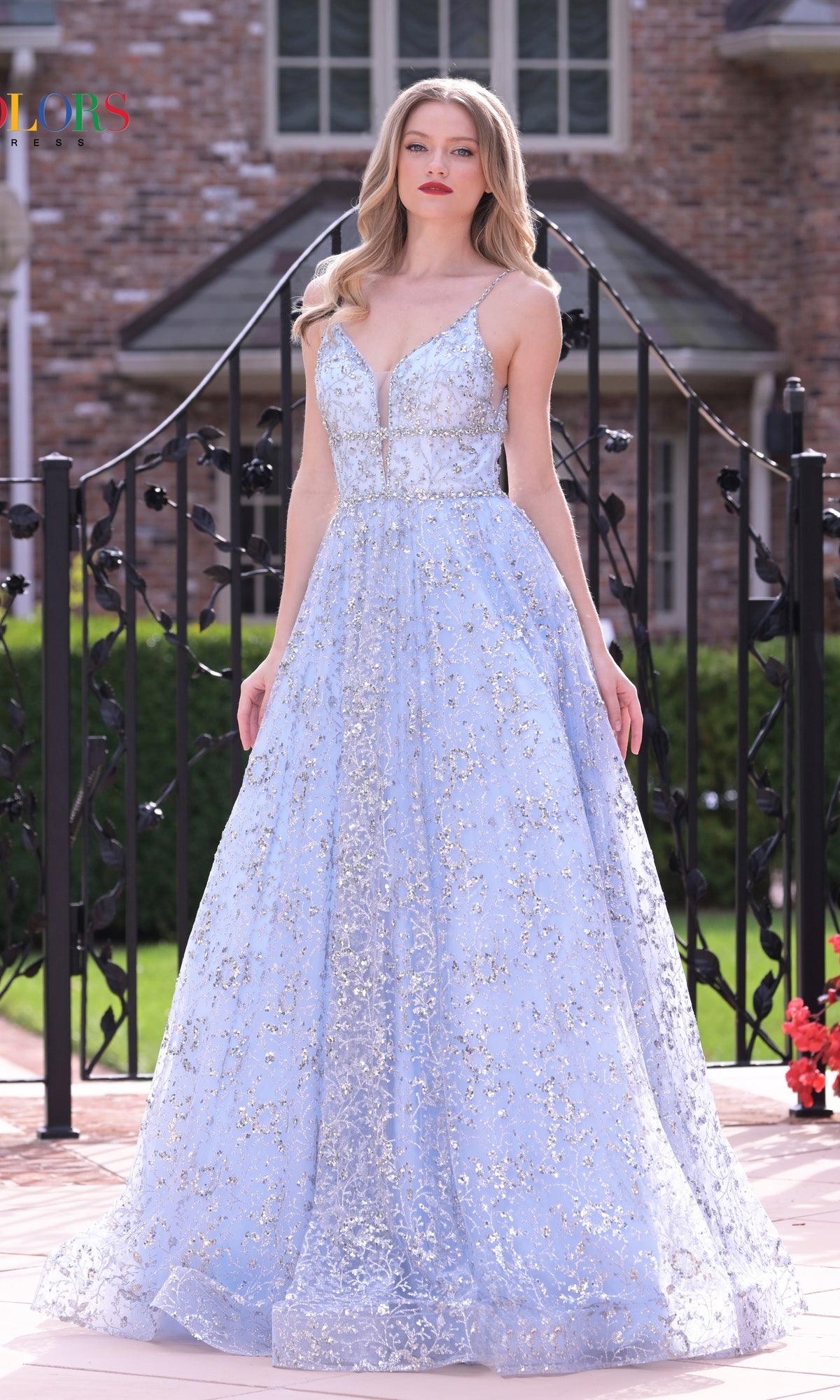 A woman in the Long Glitter Princess Prom Ball Gown 2288 stands outdoors by a brick building and black railing.