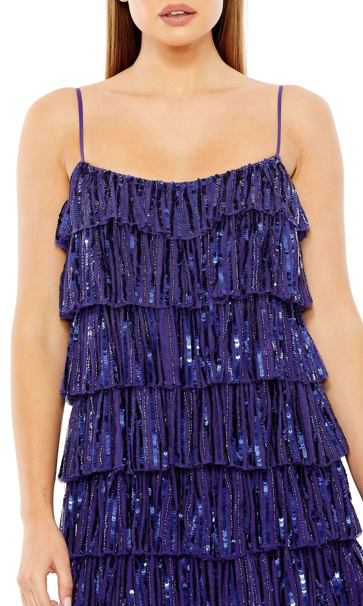 A woman wears the Mac Duggal 23001—a short, sleeveless semi-formal dress with thin straps, layered ruffles, and blue sequin beading.