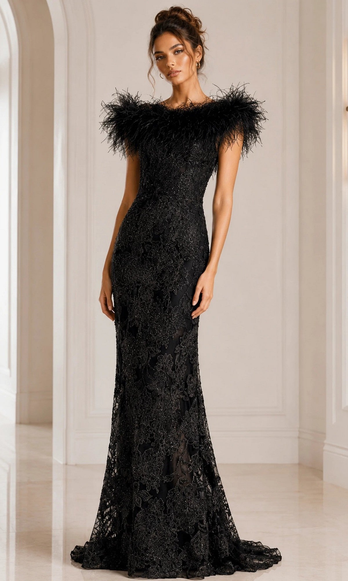 A woman wearing the Jovani 23030, a long black formal dress crafted from beaded floral lace with feathered shoulders, stands in a white, elegant interior space.