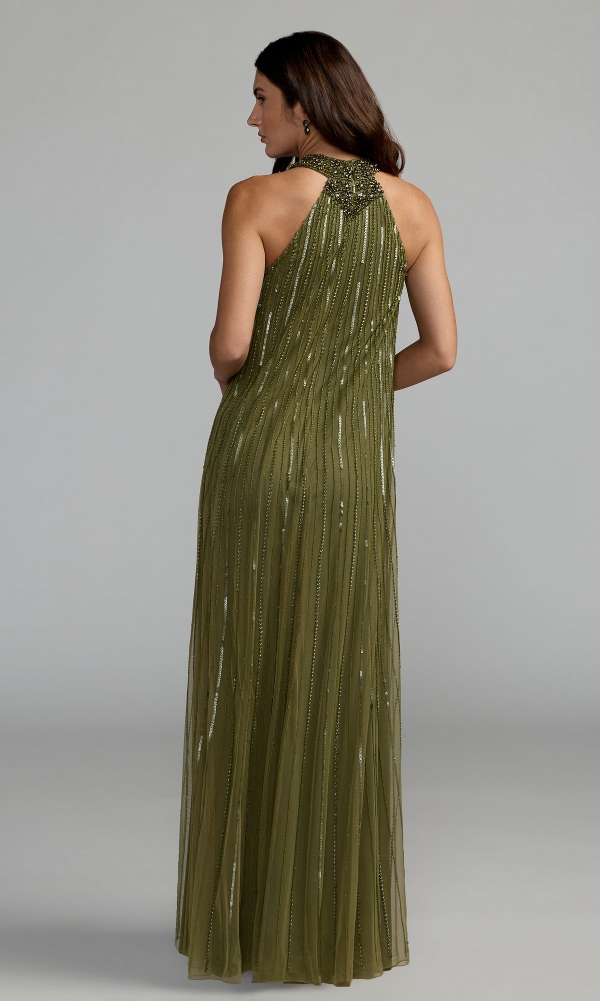 A woman is seen from behind wearing the Mac Duggal 23043 long formal dress, a floor-length, sleeveless gown in olive green featuring bead embellishments and a high neckline; the background is a plain light gray. This elegant look perfectly showcases the refined style of this embellished mesh dress.