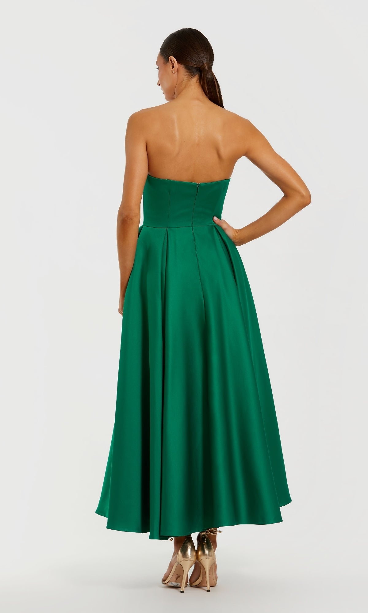 Green strapless dress worn by a model on a white background