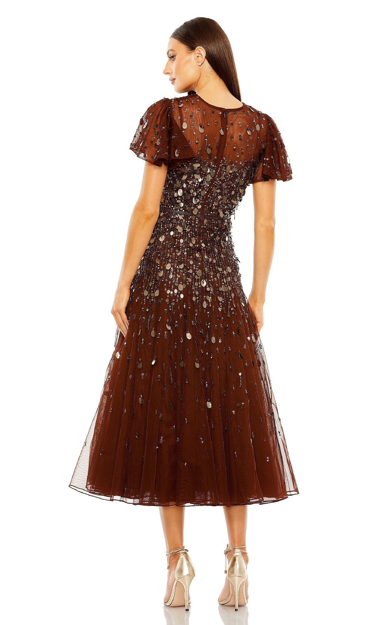 A woman stands facing away, showcasing the back details of the Mac Duggal 24018 brown tea-length party dress with short sleeves and sequins. She completes her elegant look with metallic high-heeled shoes.
