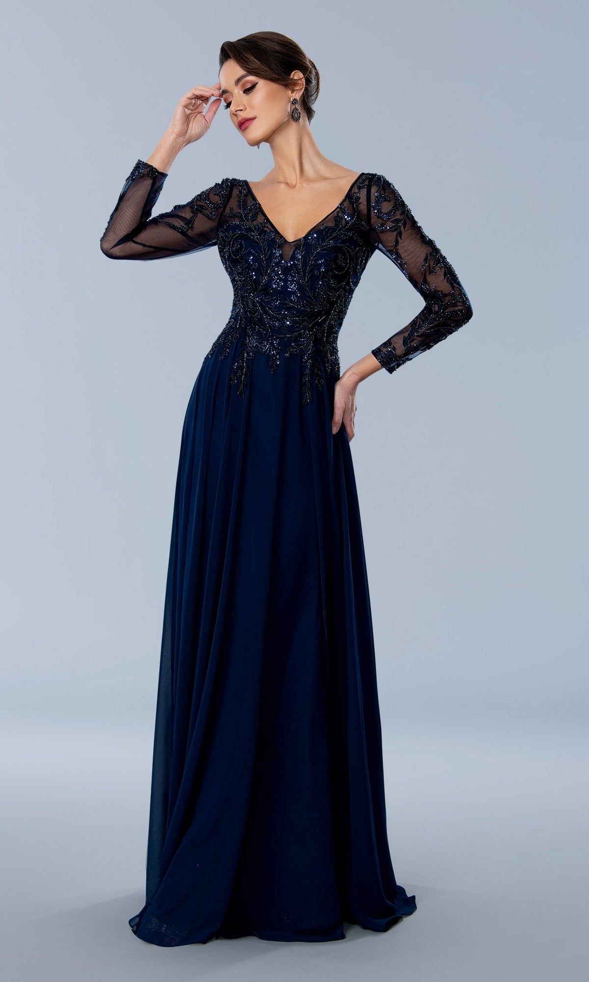 Stella Couture 24308 navy long-sleeved formal gown featuring a V-neckline, sheer sleeves, and a beaded lace bodice.