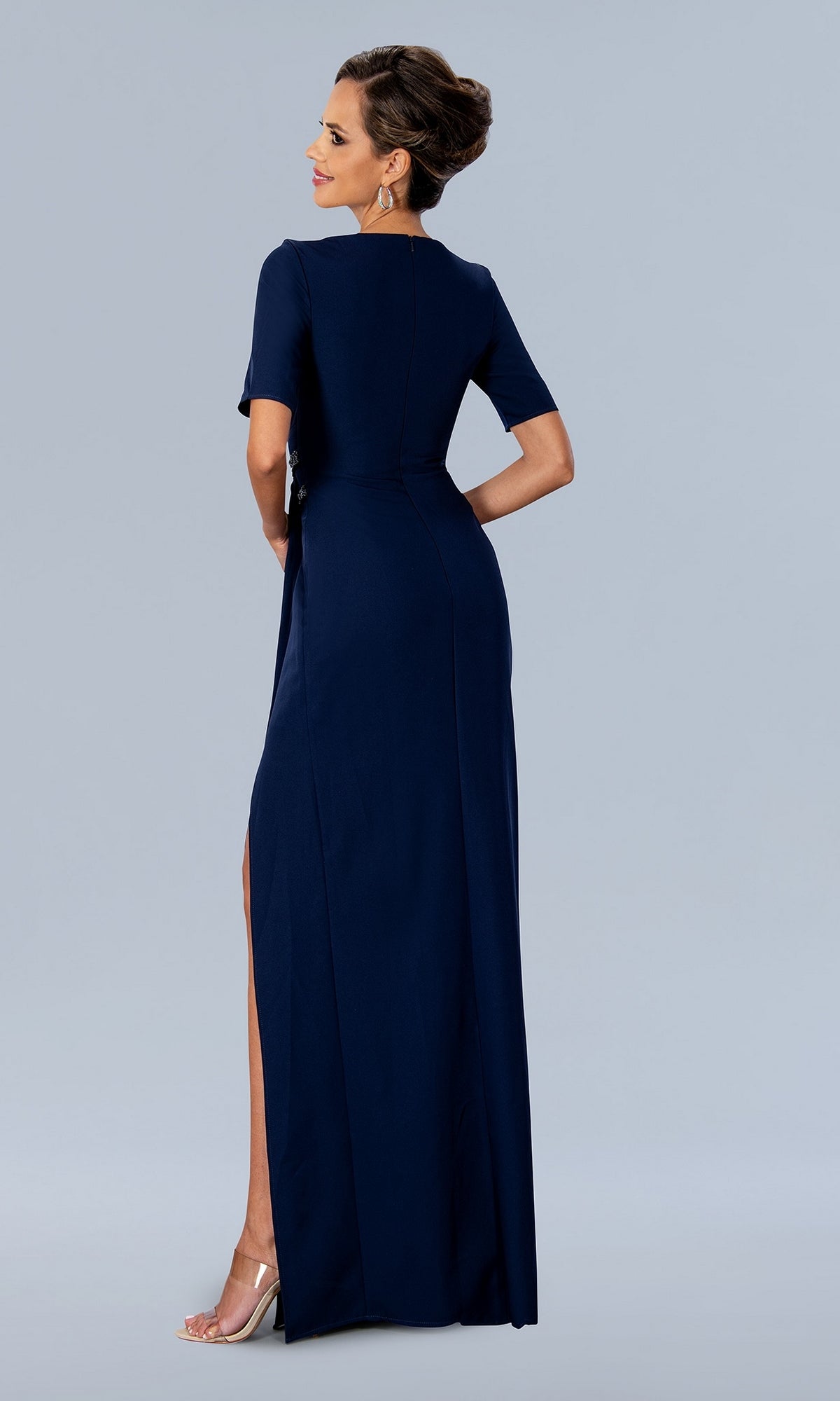 A mother of the bride wears a Stella Couture 24317 floor-length, dark navy blue evening gown with short sleeves and a high side slit.