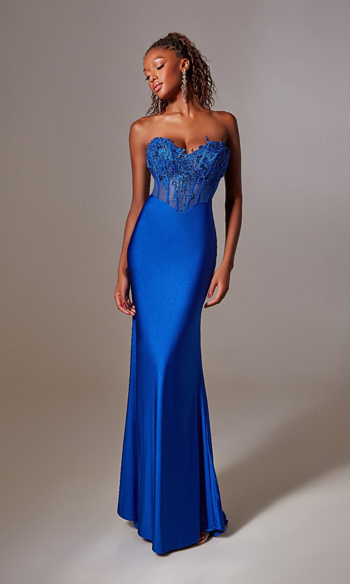 A woman in the Blue Strapless Long Prom Dress: Aerie Couture 248 with a corset-style bodice, sheer accents, and floral details poses against a plain backdrop.