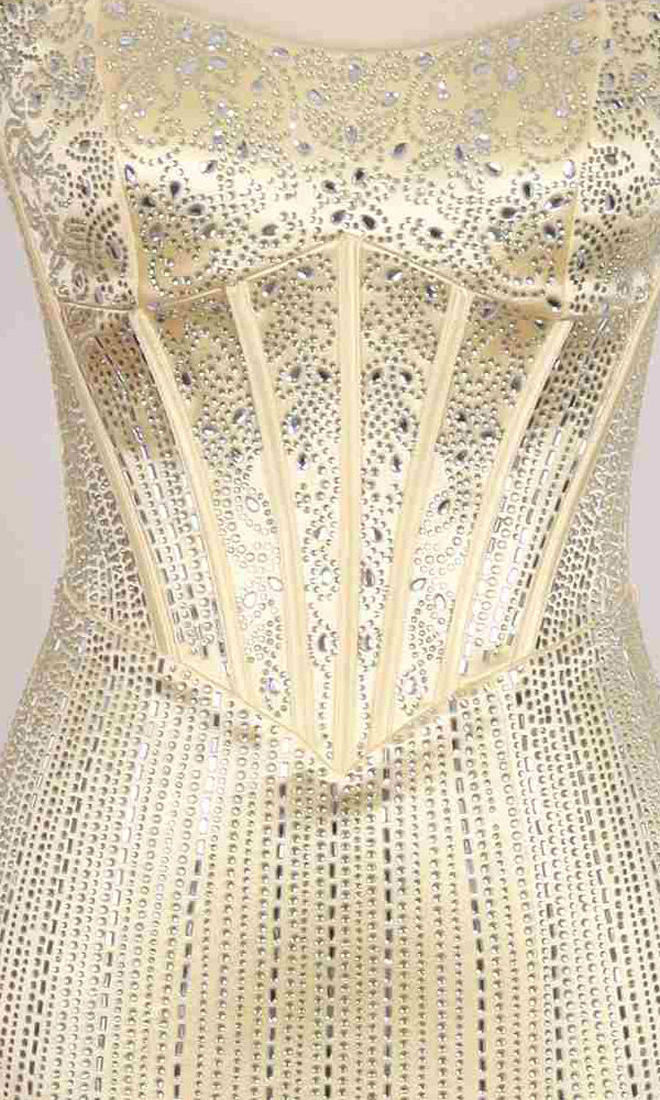 Close-up of the PromGirl Exclusive 250234: a strapless satin long prom dress featuring a structured corset, linear beading, and sparkling rhinestone patterns on light gold fabric.