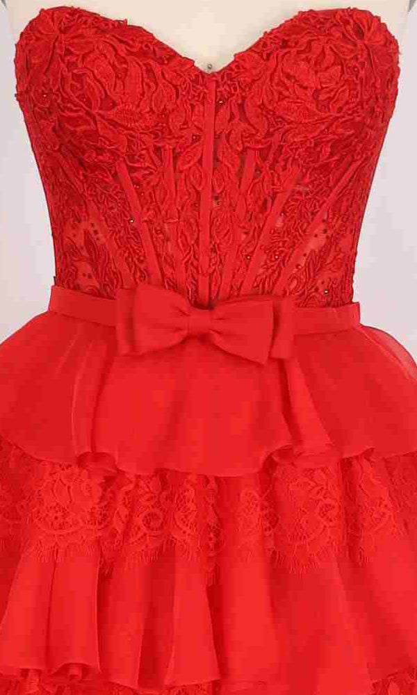 A close-up of the PromGirl Exclusive 250238: a strapless red lace long prom dress featuring layered ruffles, a lace corset bodice, and a fabric waist bow—perfect for an elegant princess-inspired look.