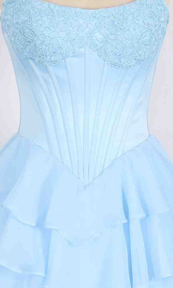 The PromGirl Exclusive 250302 is a light blue strapless long prom dress with a fitted corset bodice featuring lace on the chest and a tiered, ruffled skirt.