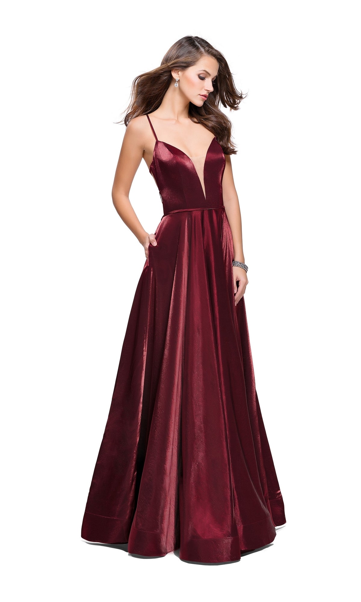 A woman wears the La Femme 25670 Long Prom Dress—a sleeveless, floor-length deep red satin A-line gown with thin straps, a deep V-neckline, and open back—standing against a white background.