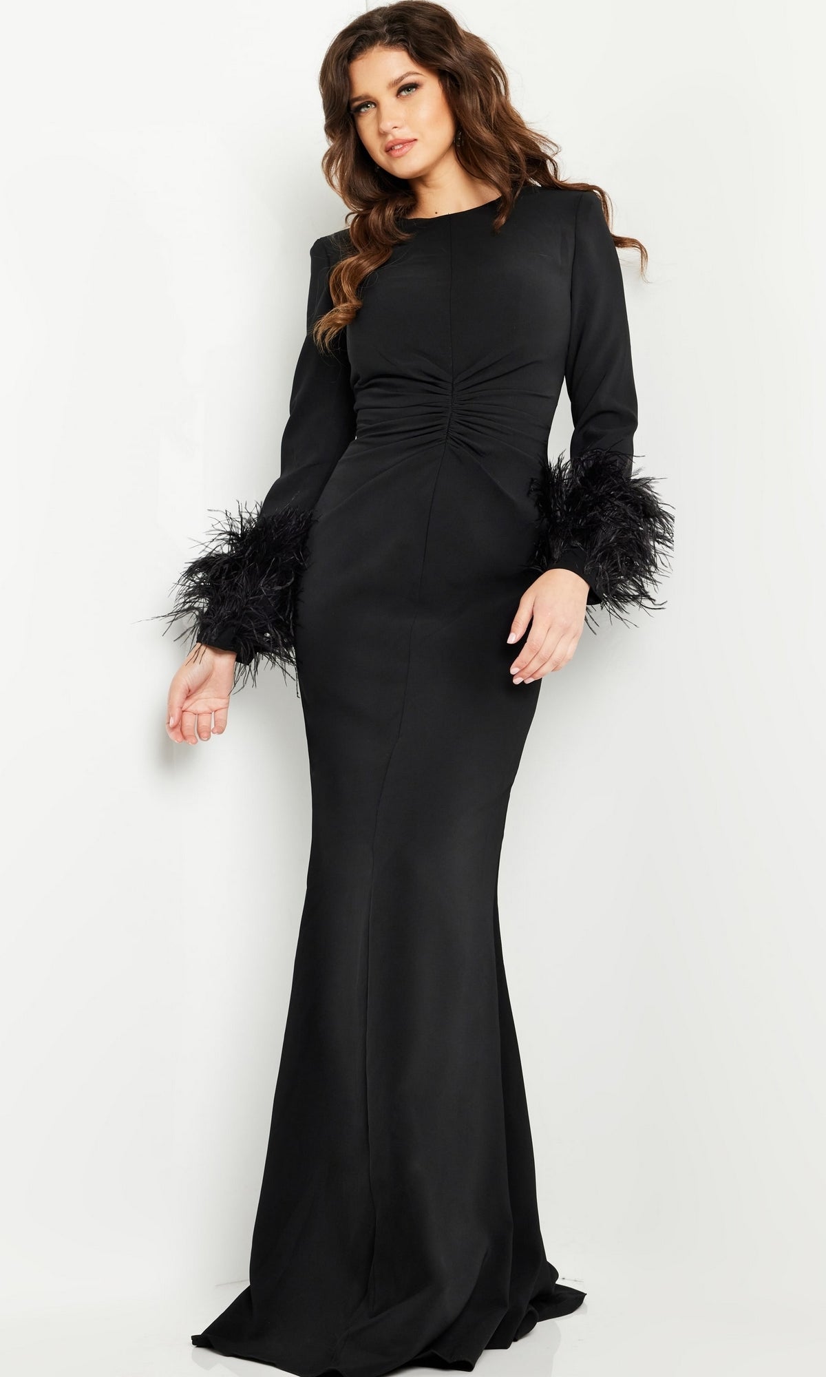A woman models the Jovani Long Sleeve Long Black Formal Dress 25898 with feathered cuffs, standing against a plain white background.