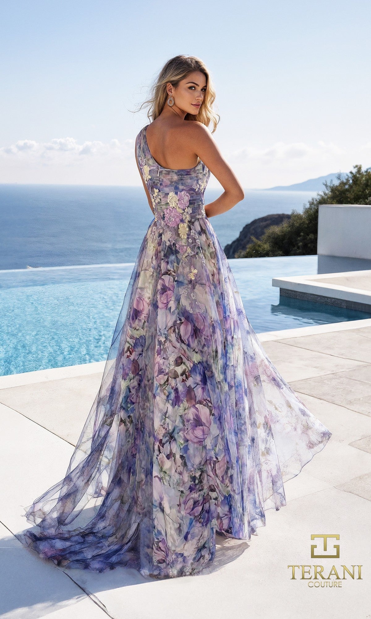 A woman stands by an infinity pool wearing the Long Formal Dress: Terani 261P6696, a floor-length, one-shoulder chiffon gown in purple floral tones. The Terani Couture logo is displayed in the bottom right corner.