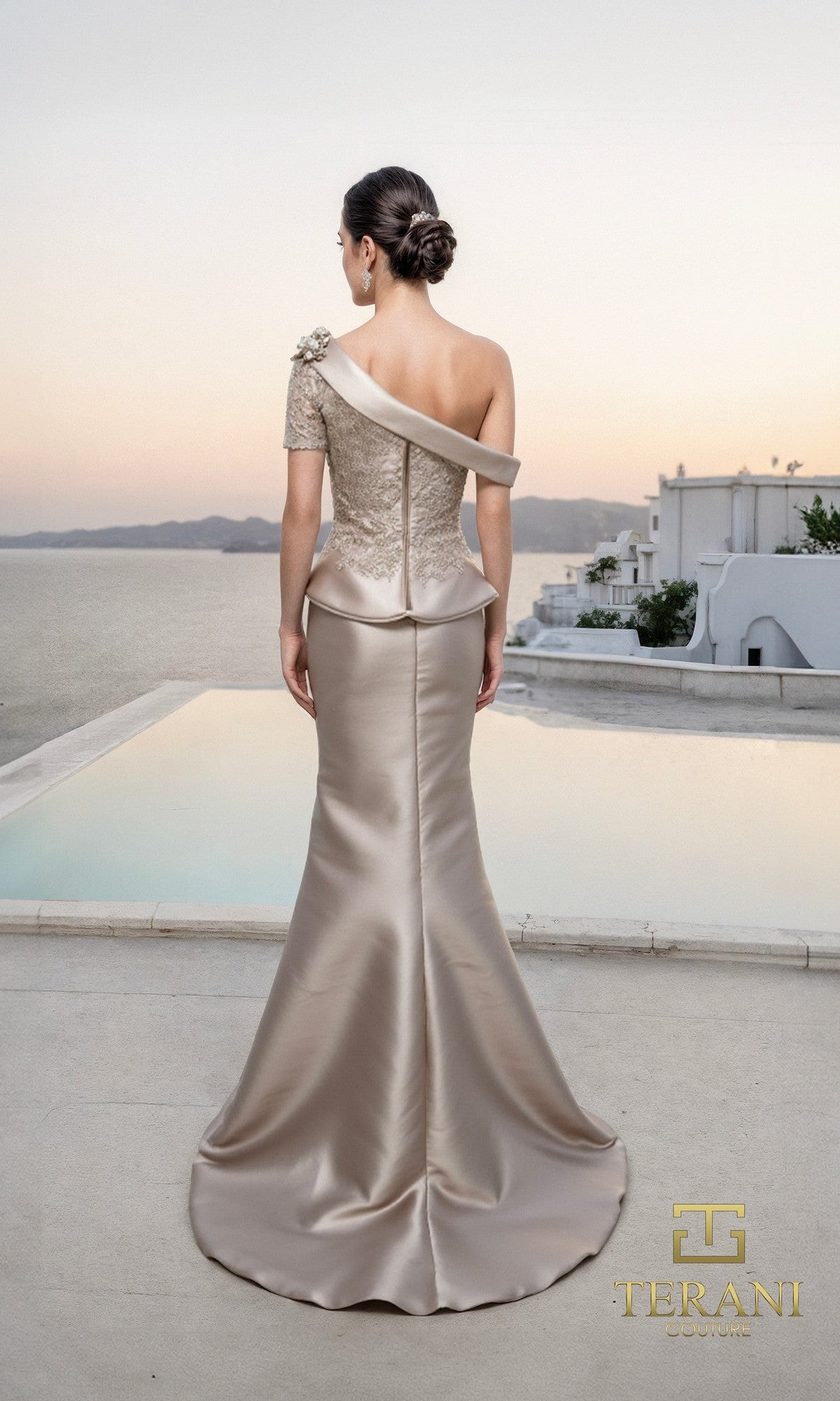 A woman in an elegant, off-shoulder, embroidered Mikado gold Long Formal Dress: Terani 261M6408 stands by a pool with a scenic coastal backdrop. The