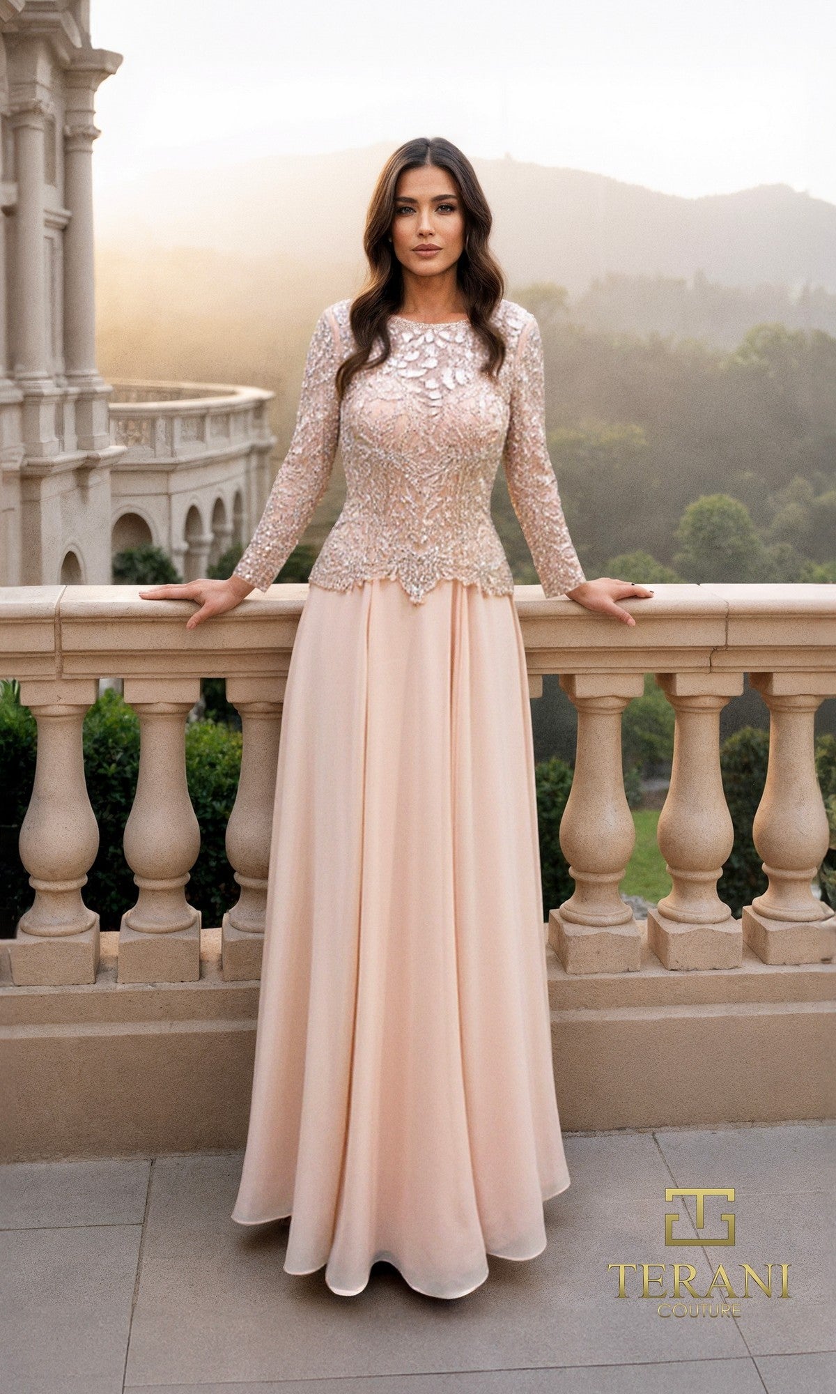 A woman stands on a stone balcony in a champagne Terani 261M6439 long formal dress with intricate beadwork on the bodice and sleeves, overlooking a cityscape and greenery.