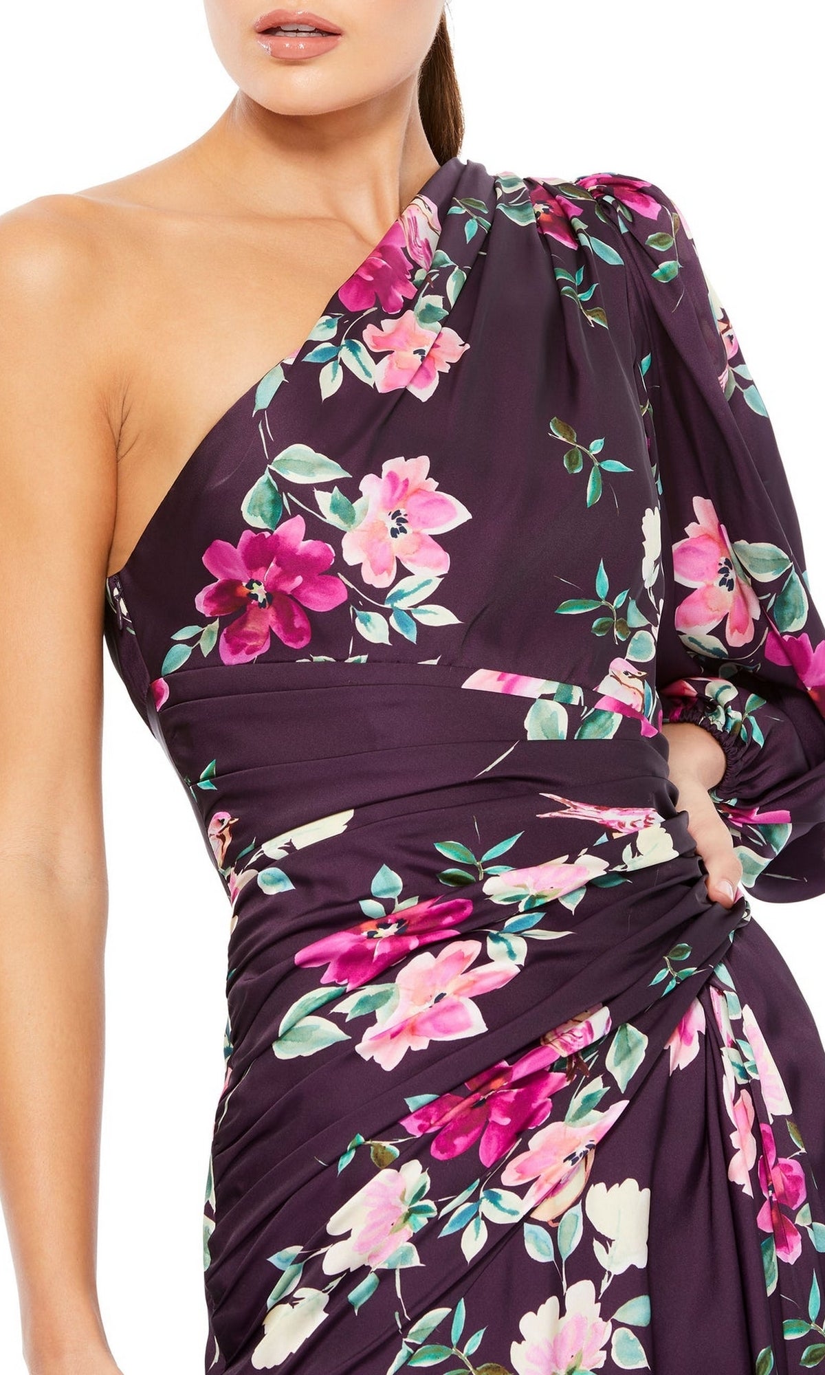 Confident woman in the Plum Floral Long Formal Dress (Mac Duggal 2634)—a one-sleeve dark purple evening gown with pink and white floral print—stands with one hand on her hip.