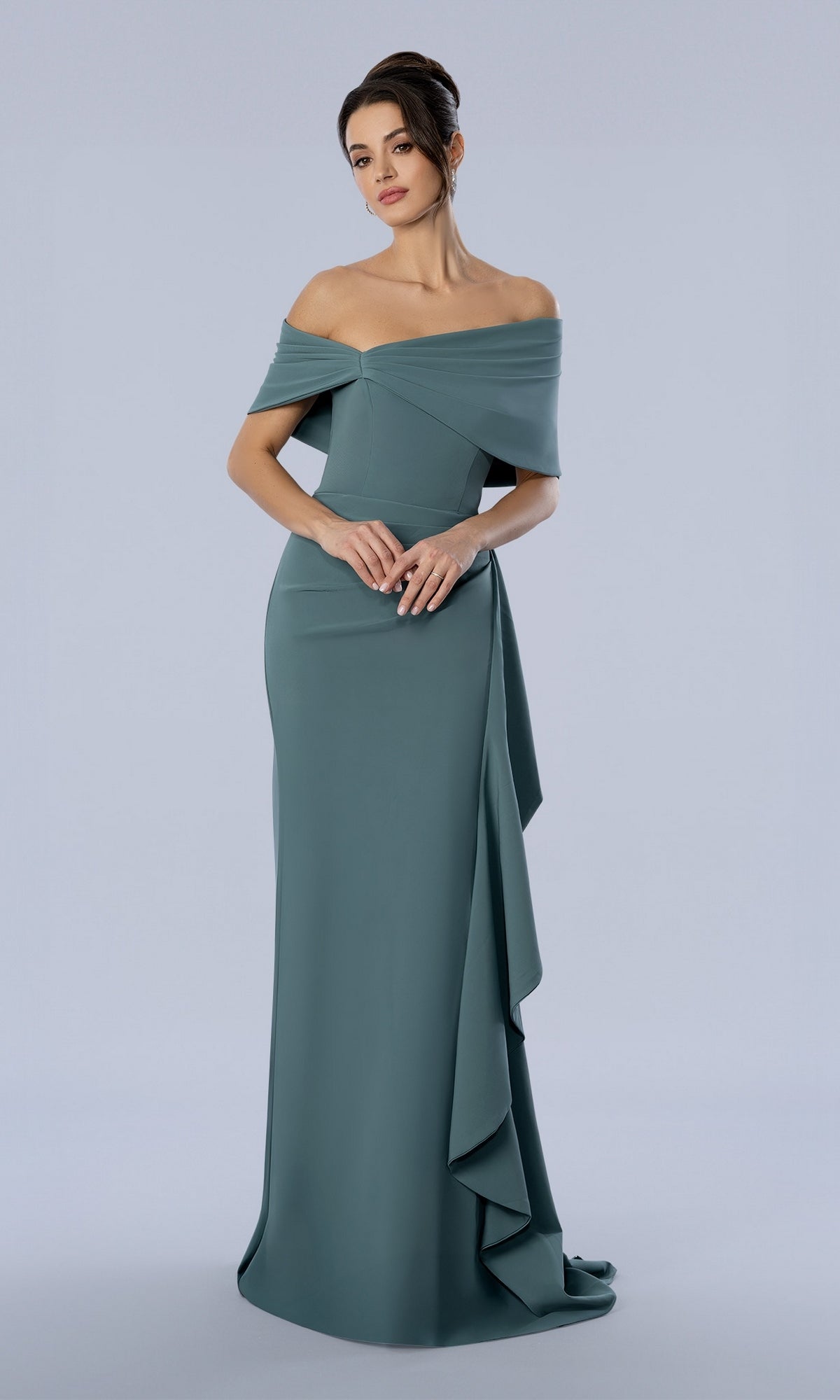 A woman wearing a sage Long Formal Dress: Stella Couture 26372, featuring a floor-length, off-the-shoulder draped bodice and side-slit ruffle detail.