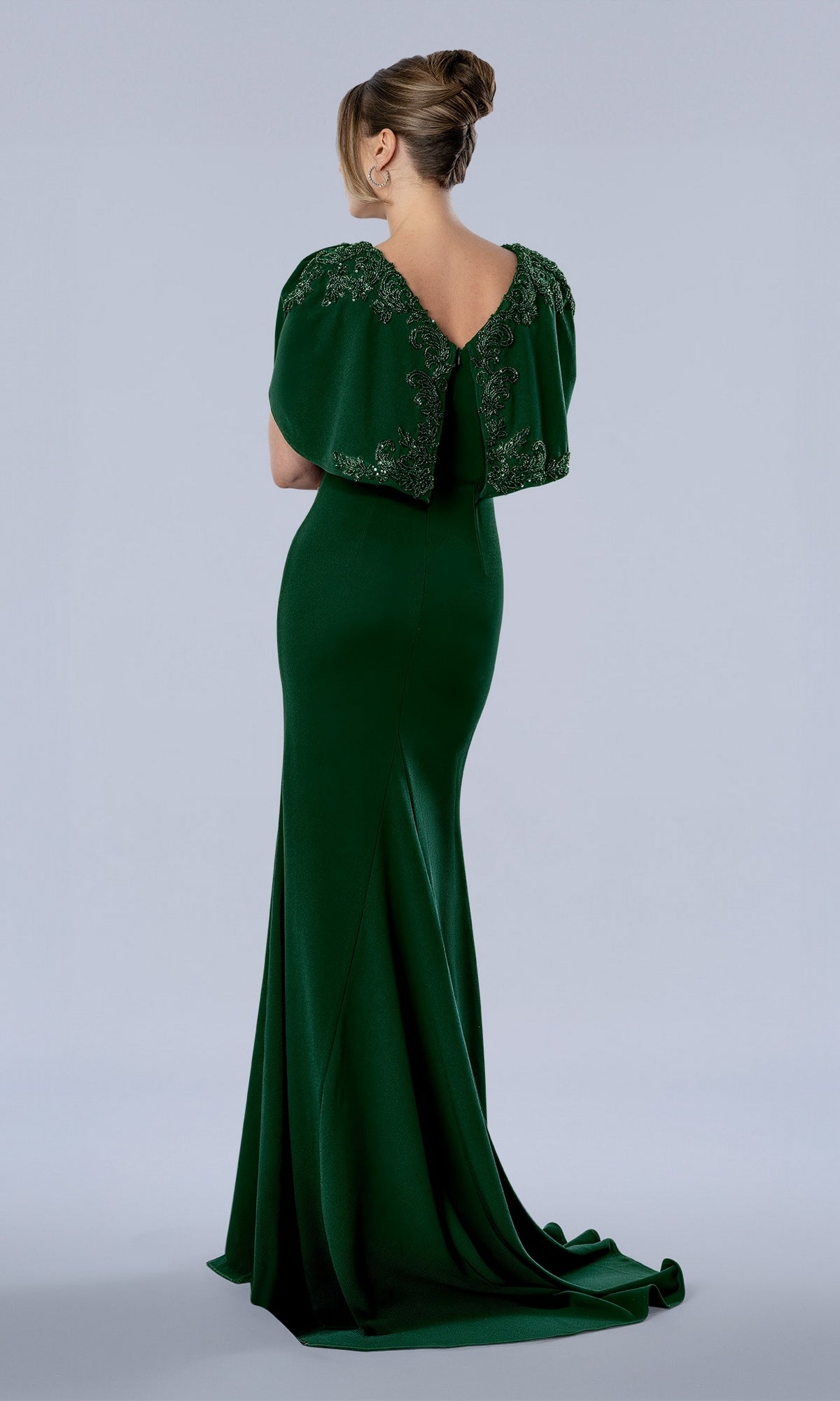 Back view of the emerald Stella Couture 26377 long formal dress featuring a beaded capelet neckline and a small train.