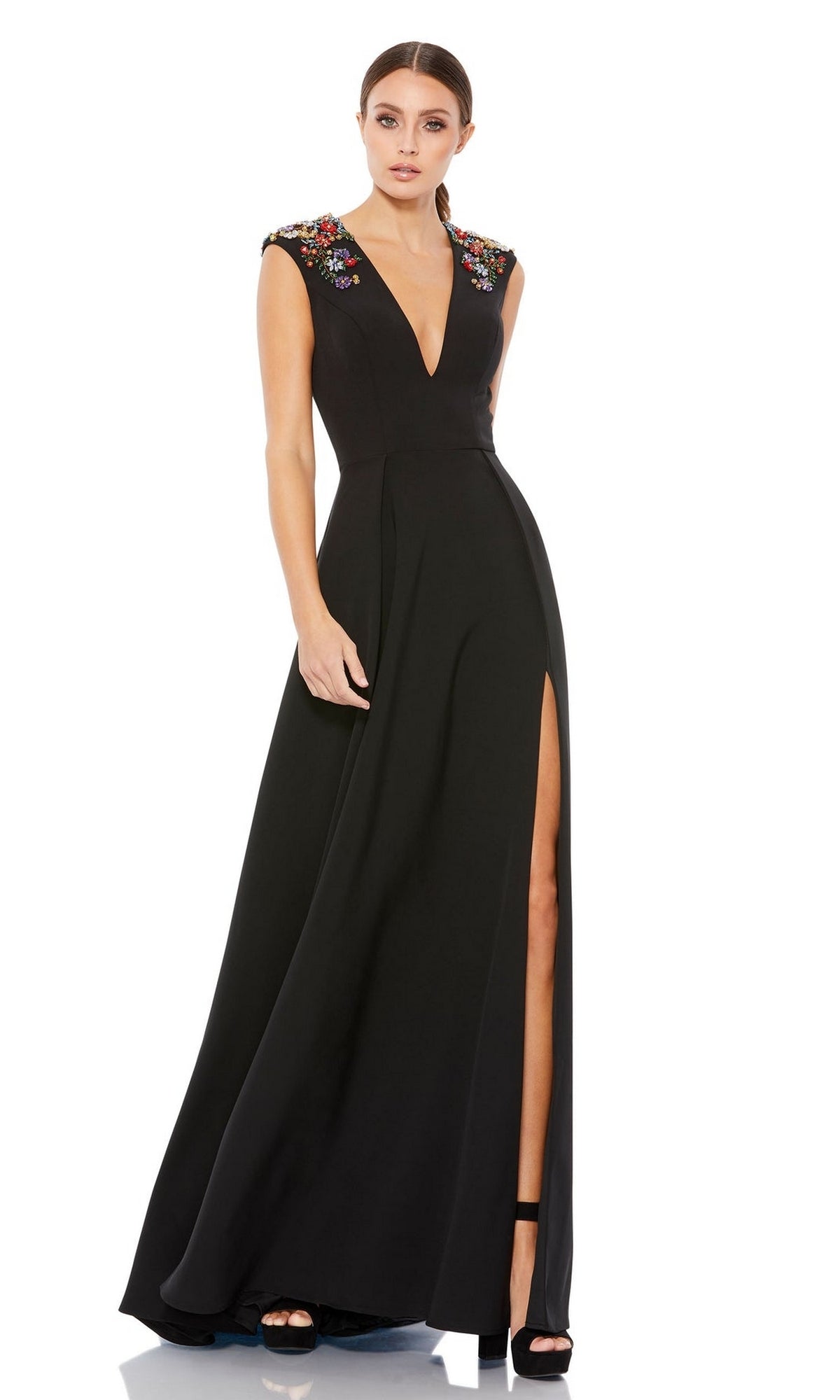 A woman models the Mac Duggal 26540 cap-sleeve long formal dress featuring an a-line silhouette, thigh-high slit, deep V-neckline, and embroidered floral shoulder details against a white background.