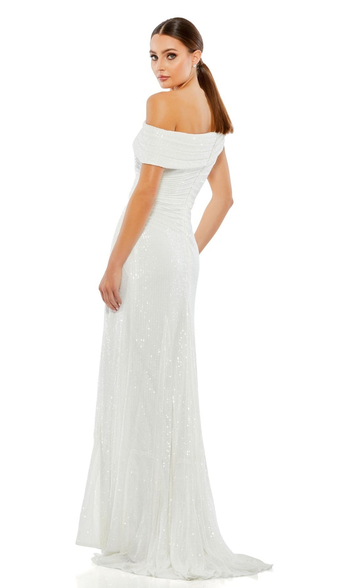 Woman in a Mac Duggal 26550 Drop-Shoulder Sequin Formal Gown, a floor-length white dress with sequins, stands against a white background looking over her shoulder.