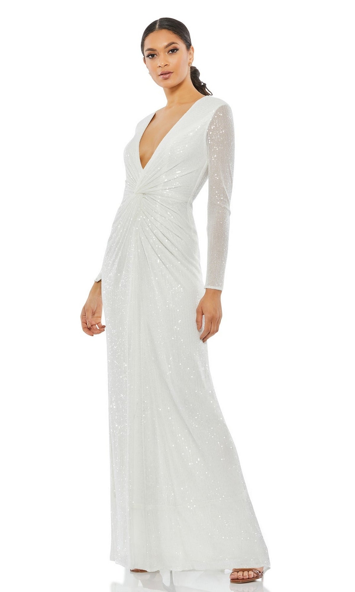 A woman wearing the Long Formal Dress 26552 by Mac Duggal—a white, sequined gown with long sleeves, a deep V-neckline, and gathered waist detailing.