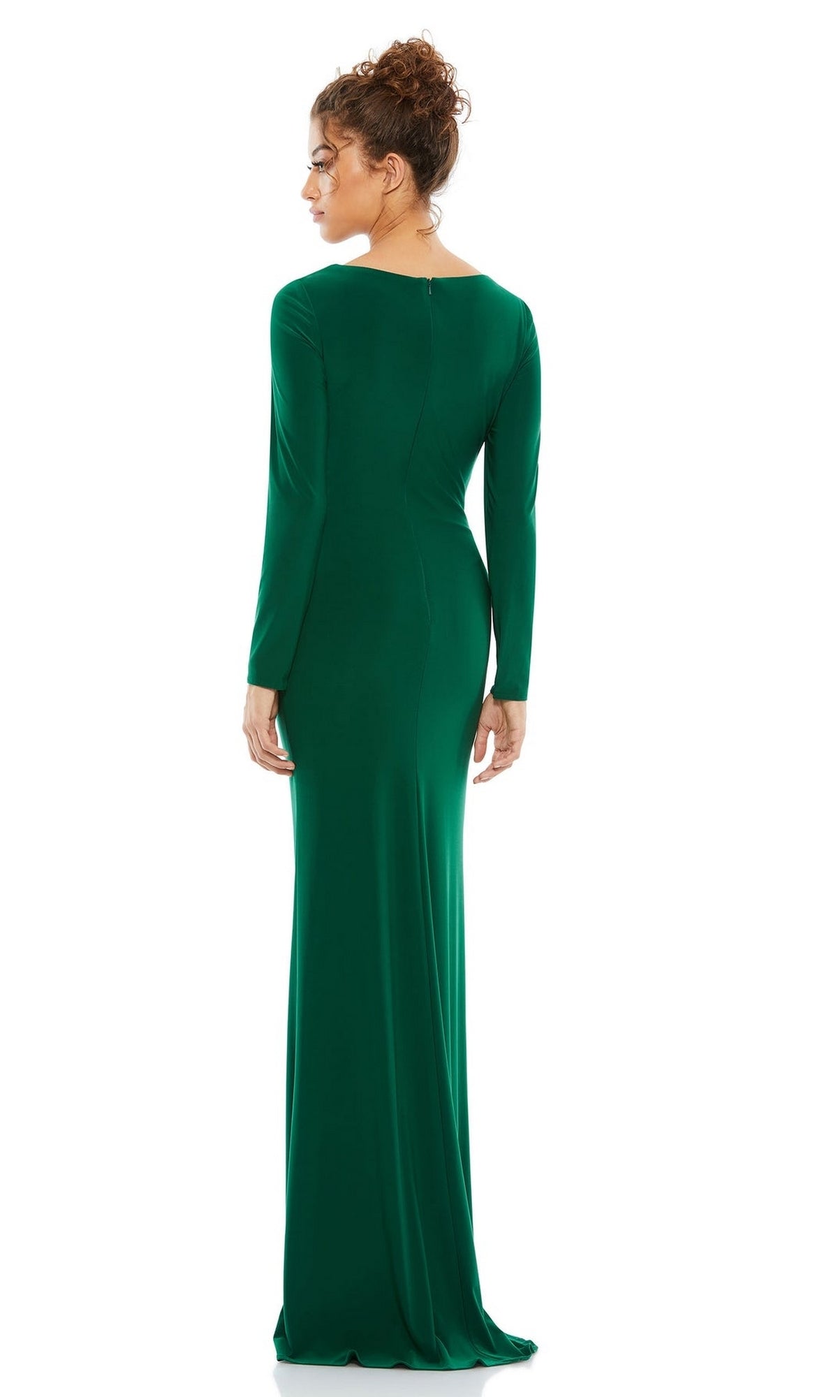 A woman faces away, showcasing the elegant back of the floor-length green Mac Duggal 26573 Long Sleeve Long Formal Dress against a white background.