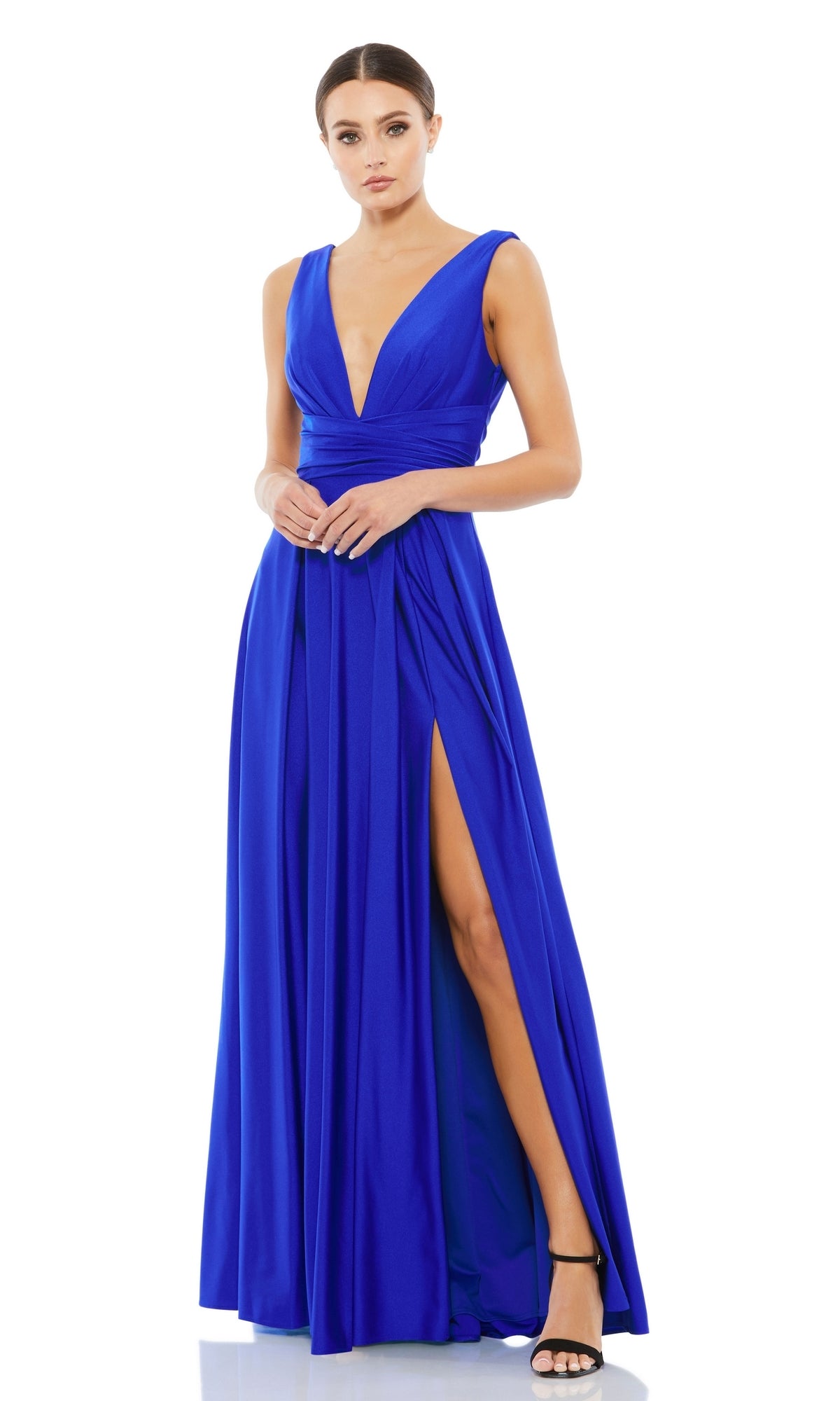 A woman wearing the Mac Duggal 26578 V-Neck Long A-Line Prom Dress with a high slit and black heeled sandals, standing against a white background.