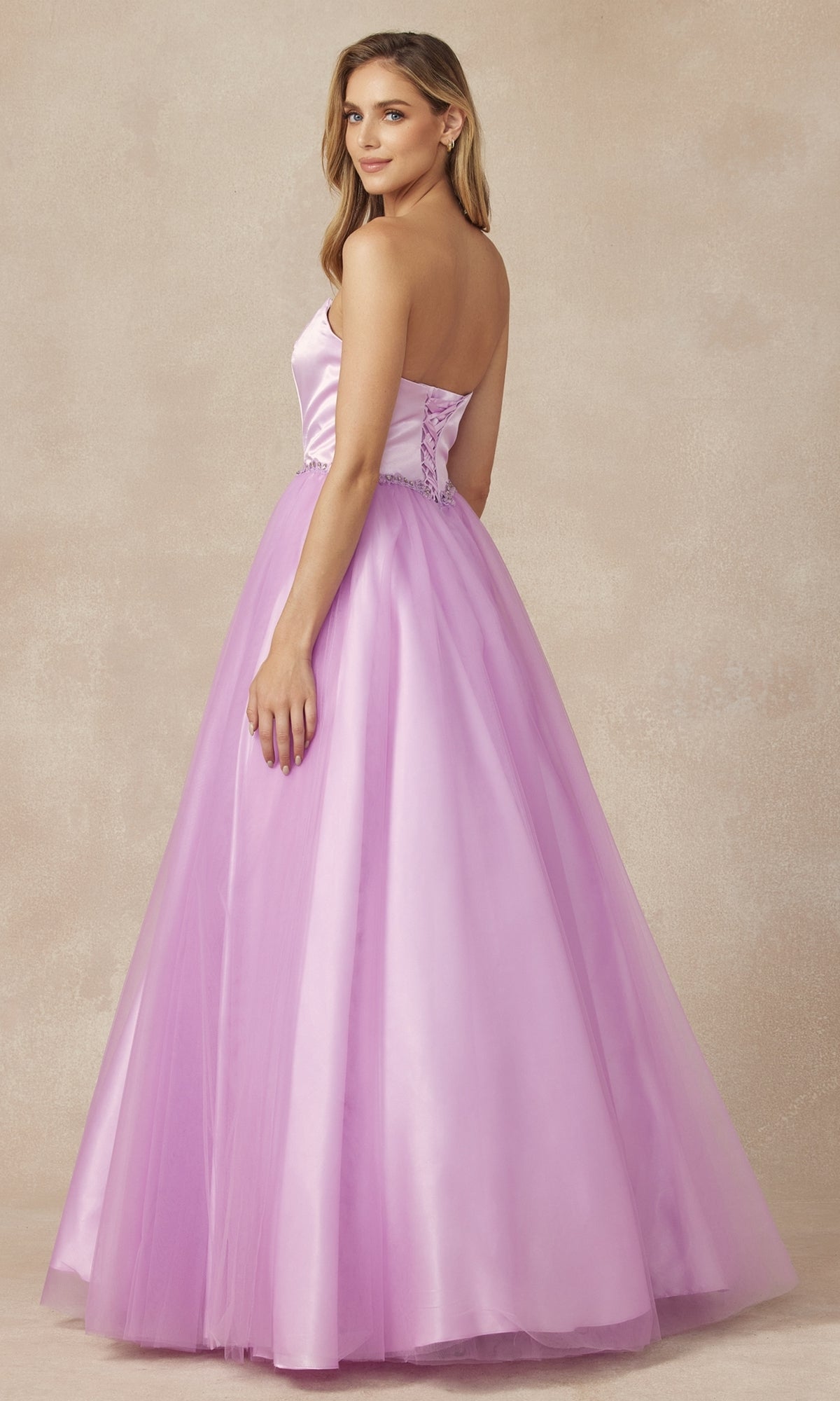 A woman in the Strapless Sweetheart Long Prom Ball Gown 265 with a corset-style back stands slightly turned against a neutral backdrop.
