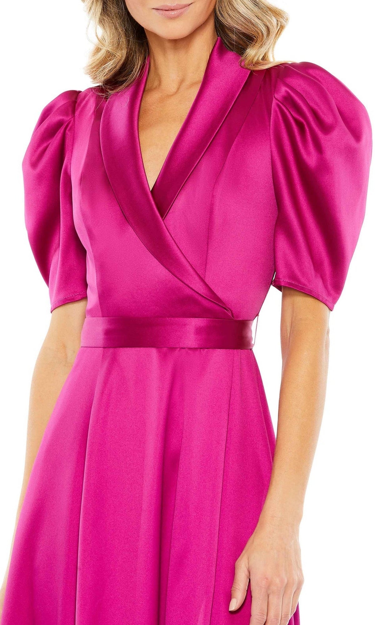 A woman in the Mac Duggal 2628 Short Sleeve Wedding Guest Dress, featuring bright pink satin fabric, puffed short sleeves, a V-neckline, and a fitted waist at tea length.