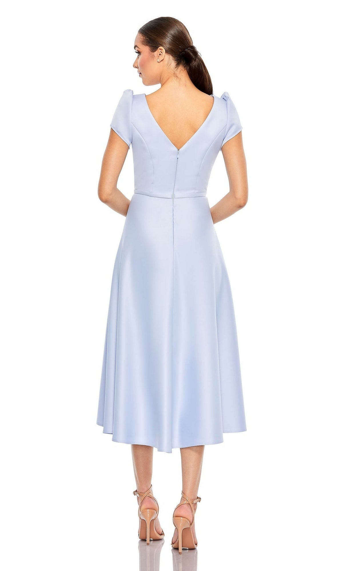 A woman faces away in the Short Wedding Guest Dress 26663 by Mac Duggal—a light blue, knee-length a-line dress with a V-back, fitted bodice, flared skirt, and nude heels—ideal for any occasion.