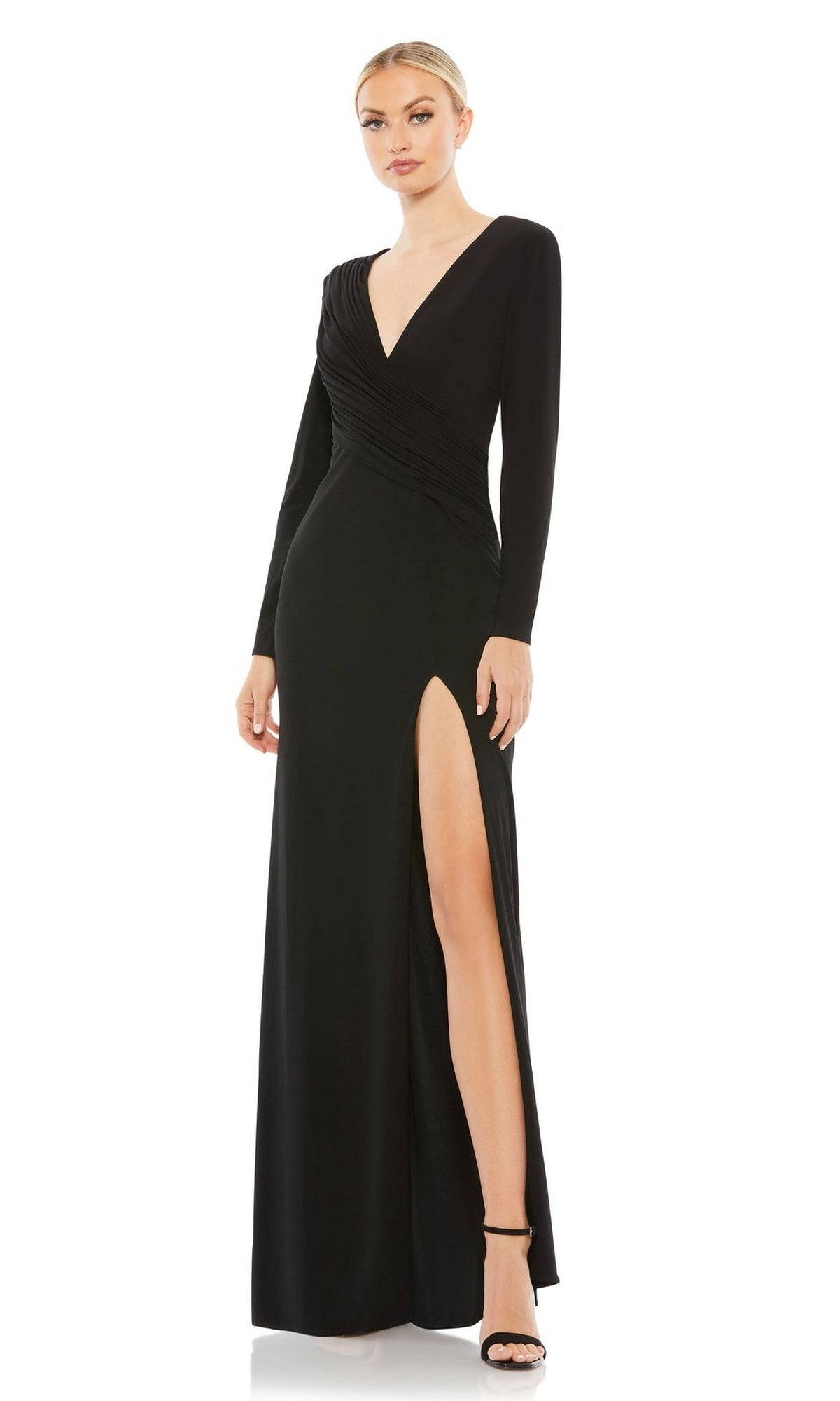 A woman wears the Mac Duggal 26686 long sleeve long formal dress with a deep V-neckline and high slit, paired with black heels.