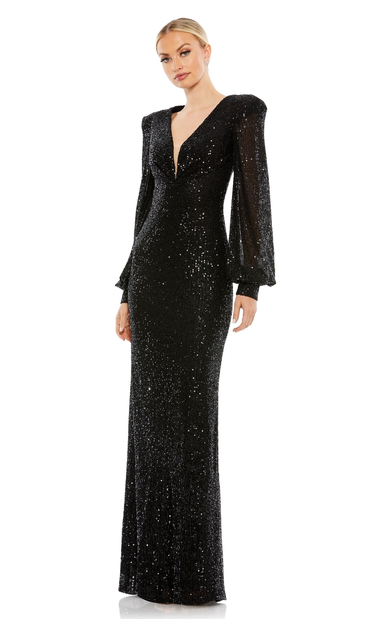 A woman stands in the Long Formal Dress 26722 by Mac Duggal, a floor-length sequin gown with long sleeves, a deep v-neckline, and subtle shoulder padding.