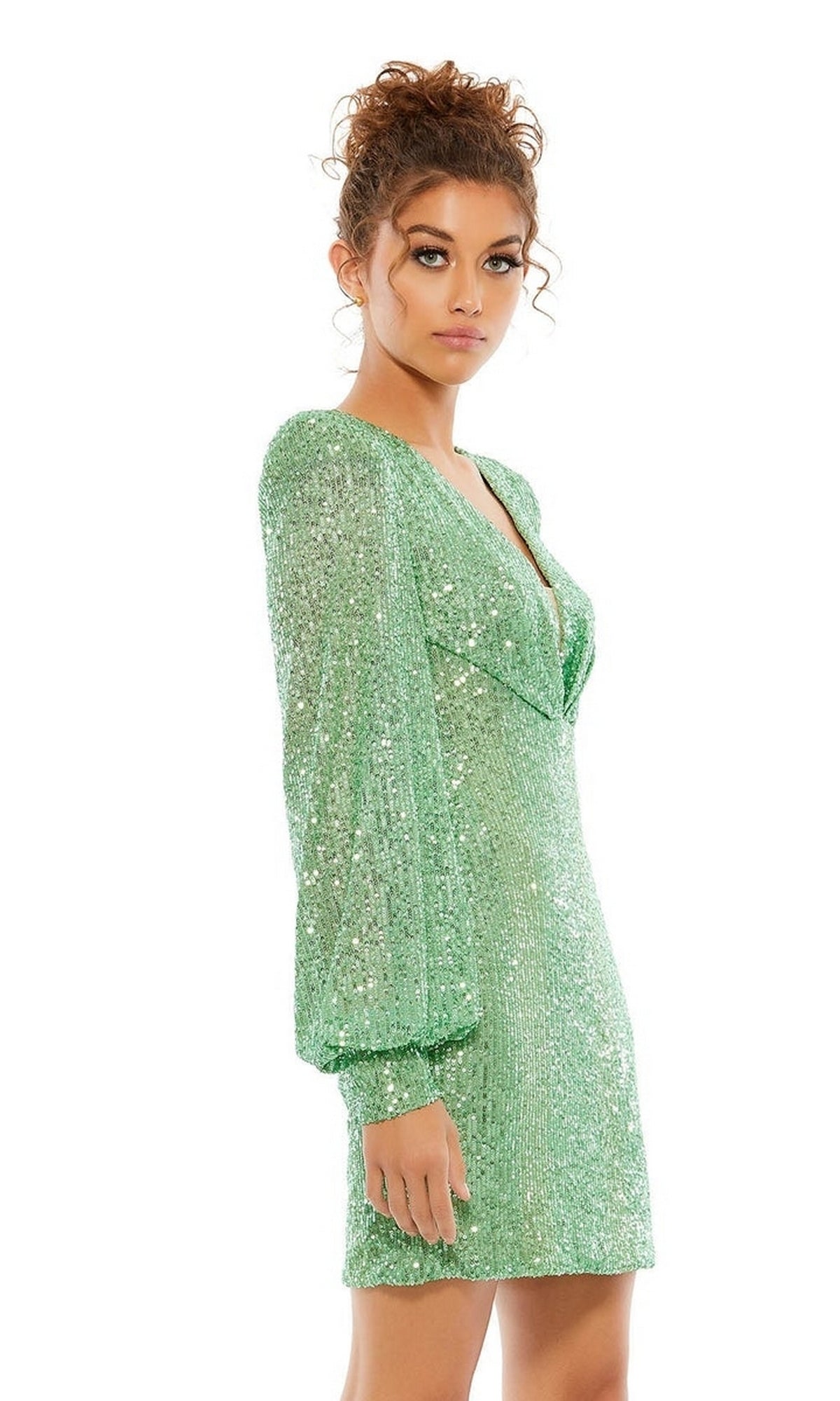 A woman with curly hair wears the Long Sleeve Sequin Hoco Dress: Mac Duggal 26865, featuring a V-neckline and long sleeves, as she stands facing the camera.