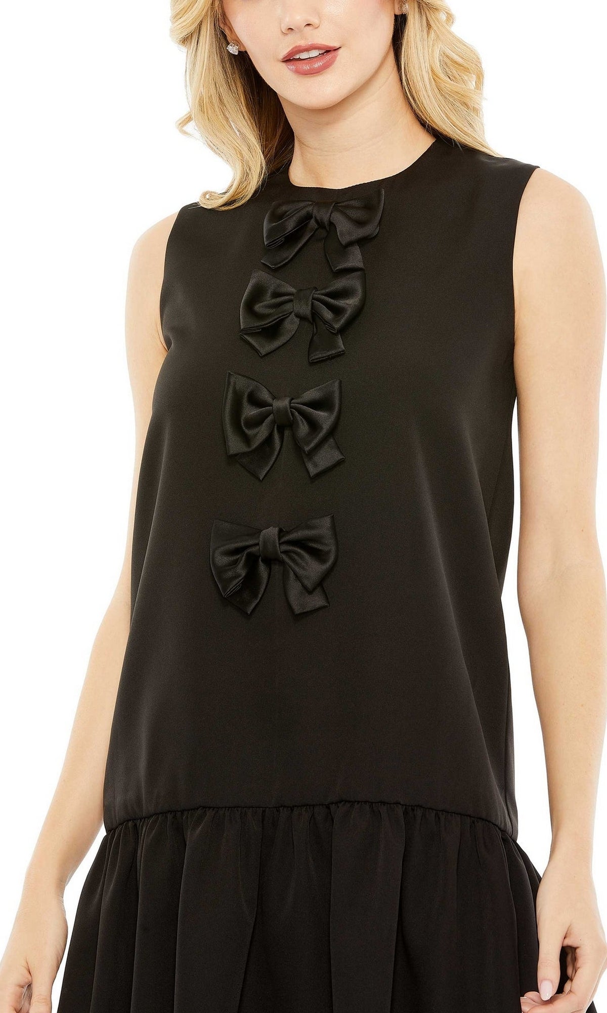 A woman wears the Short Wedding Guest Dress 27032 by Mac Duggal, featuring a sleeveless design, three black satin bows down the front, a gathered skirt, and an elegant a-line silhouette.