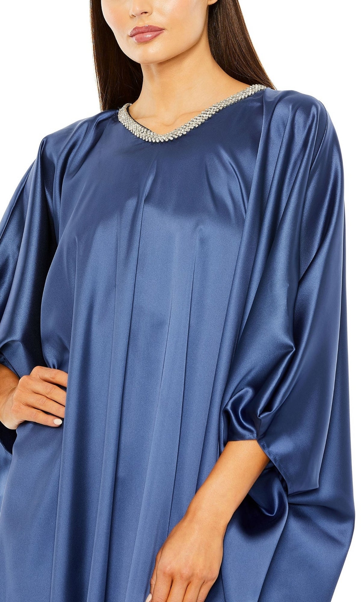 A woman poses with one hand on her hip in the Long Formal Dress 27071 by Mac Duggal, featuring a loose ocean blue trapeze silhouette, wide sleeves, and an embellished high neckline.