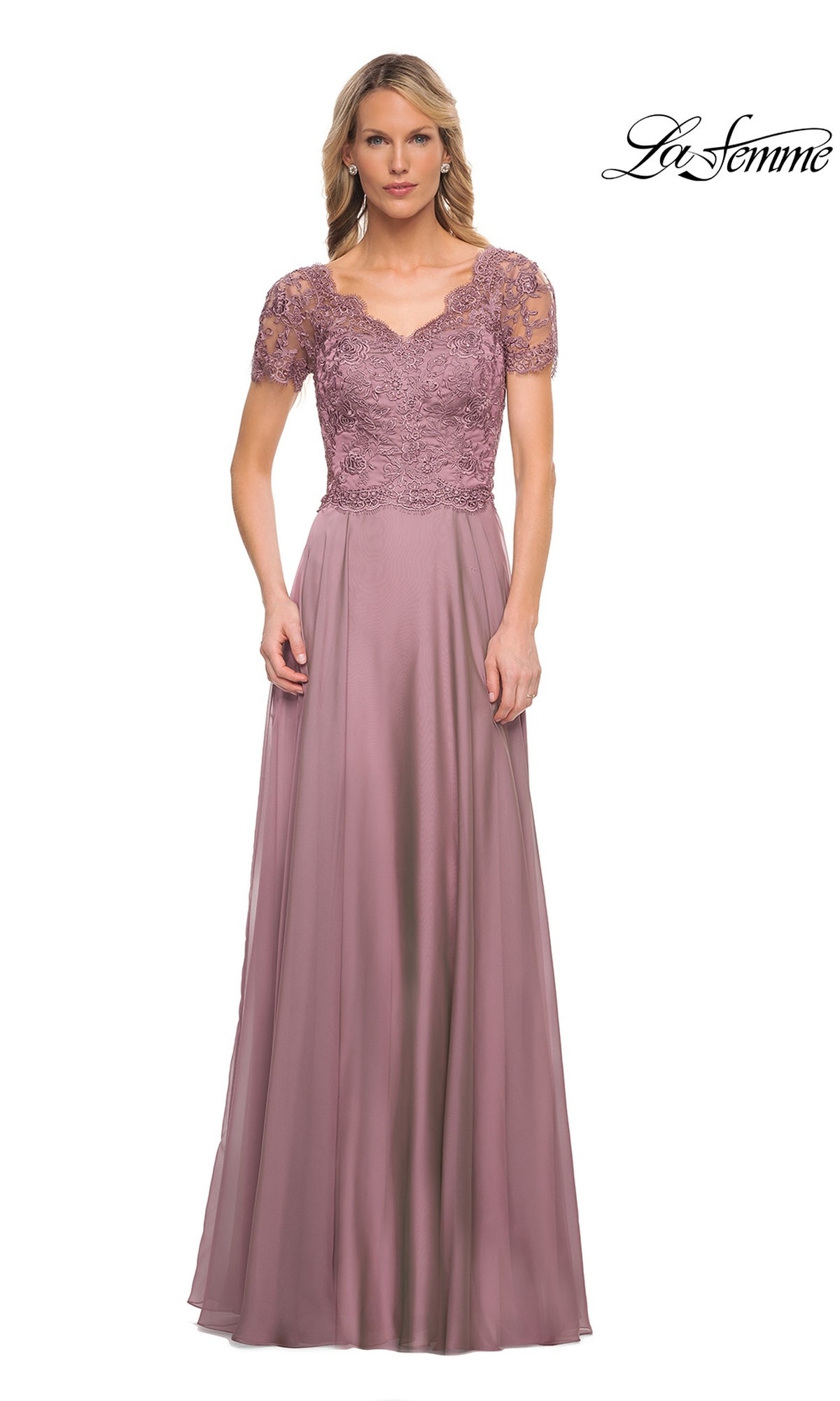 Woman in a Long Formal Dress: La Femme 27098, featuring a dusty lilac lace-embroidered bodice and chiffon A-line skirt, stands against a white background.