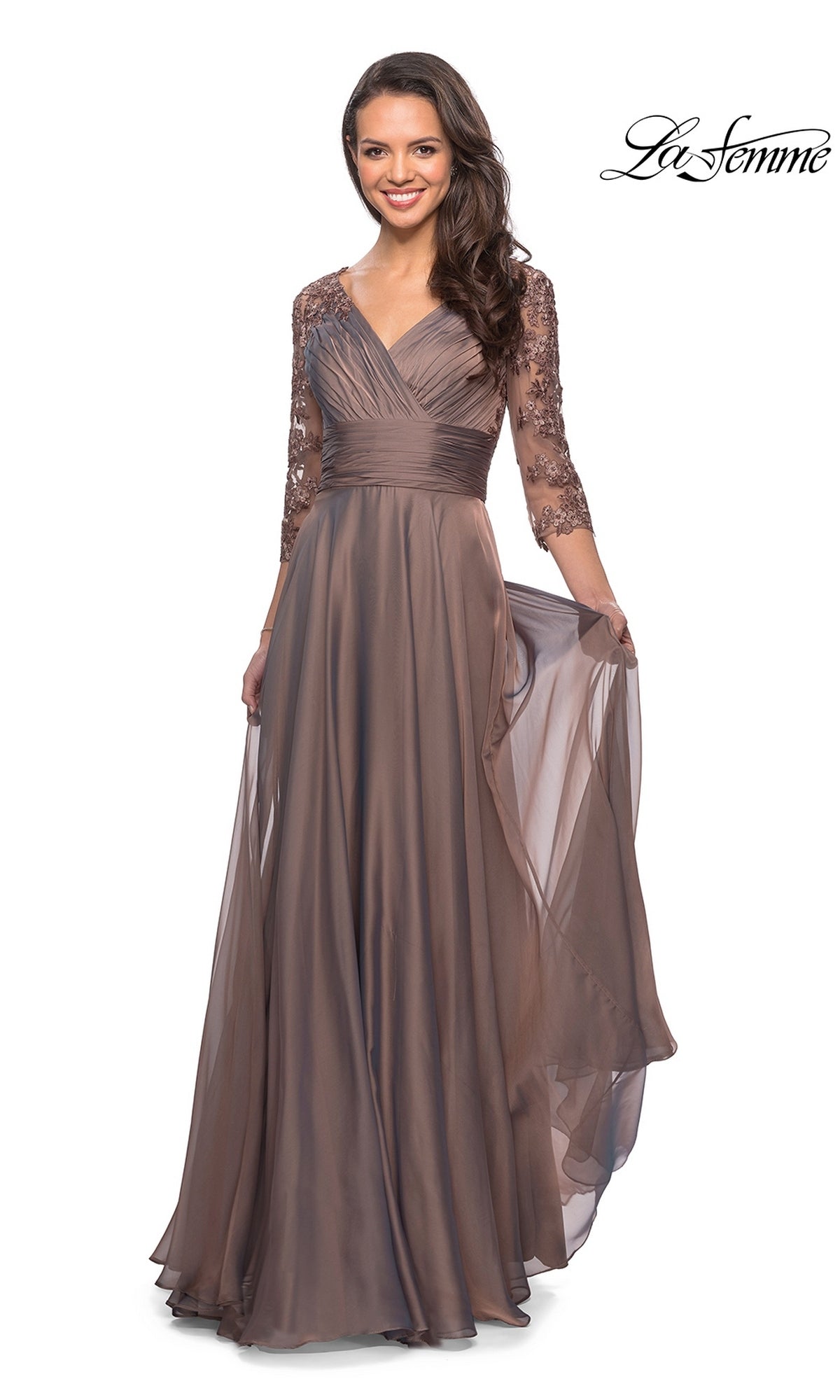 A woman wearing a cocoa-colored Long Formal Dress: La Femme 27153 featuring a V-neckline and three-quarter length lace sleeves.