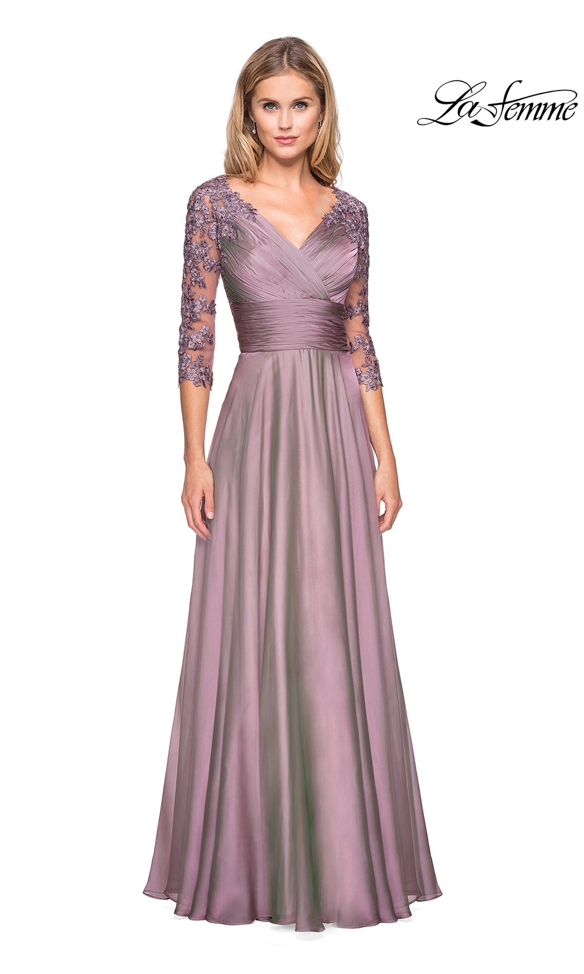 A woman wears the Long Formal Dress: La Femme 27153, a floor-length, mauve-colored modest gown with a V-neckline, pleated bodice, and three-quarter length sleeves with floral lace embroidery.