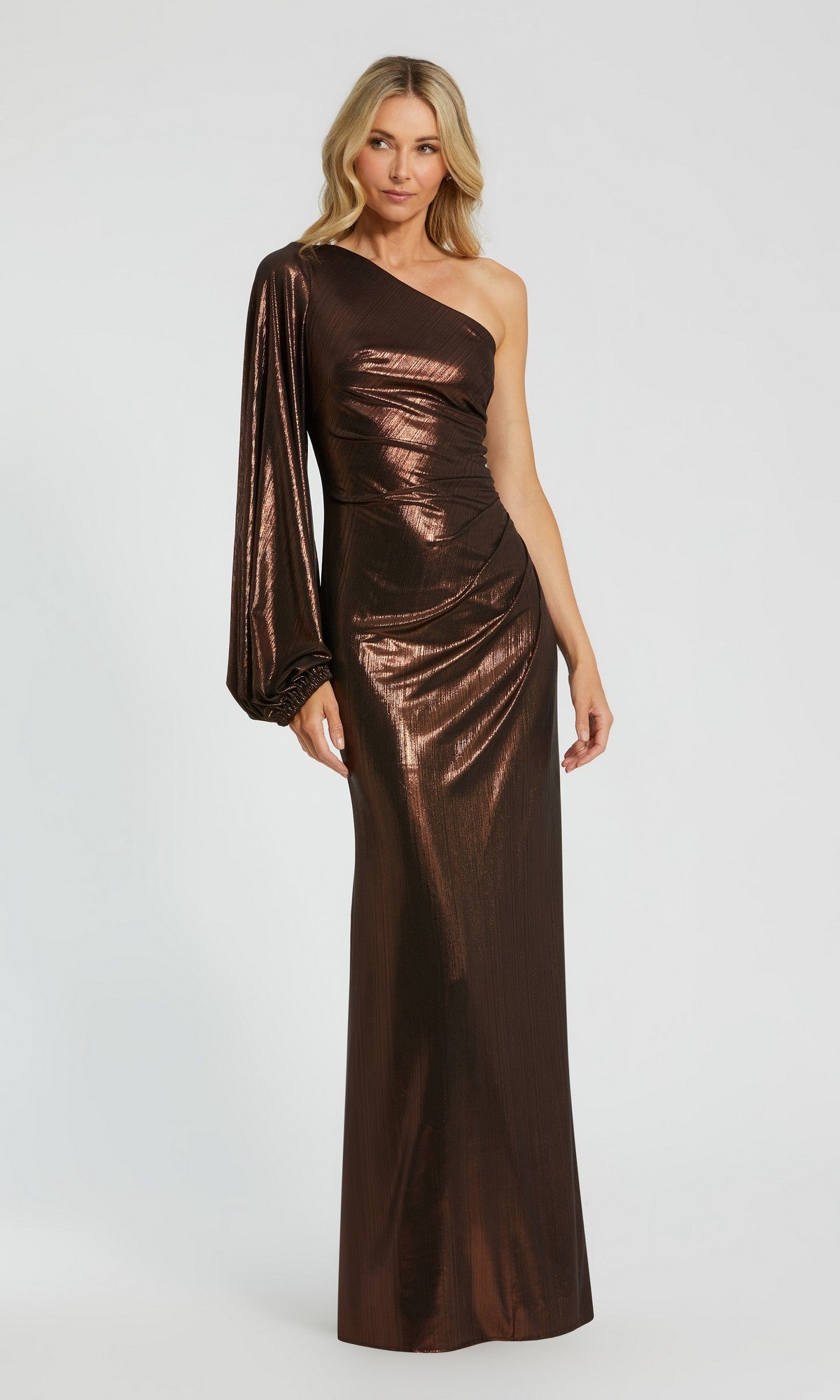 Woman wearing a chocolate Mac Duggal 27158 long formal dress featuring a one-shoulder design with a single long sleeve, standing against a plain light background.