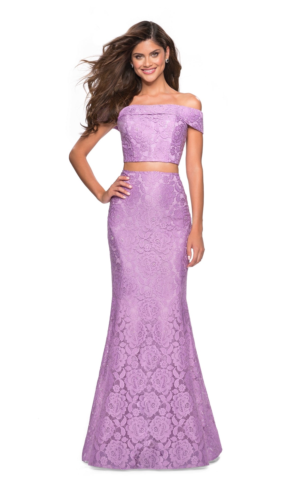 A woman smiles against a white background wearing the La Femme Two-Piece Mermaid Lace Prom Dress 27443, featuring lavender floral lace, off-the-shoulder straps, and a fitted mermaid skirt.