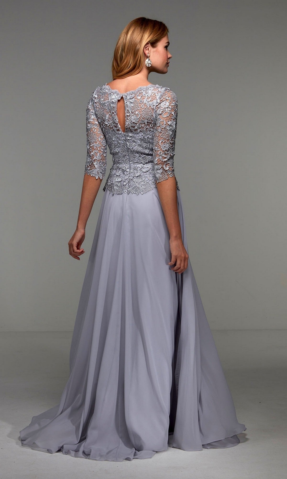 Woman wearing the Alyce 27470 long formal dress, featuring a light gray lace bodice and three-quarter sleeves, stands with her back to the camera.