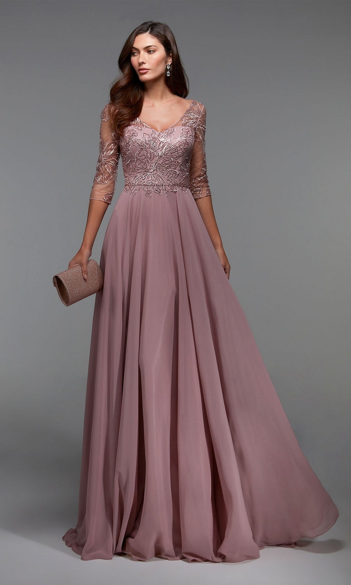 Woman in a rosewood Alyce 27475 long formal dress with a lace bodice, sheer sleeves, and chiffon skirt holds a matching clutch—an elegant mother-of-the-bride look—posed against a plain background.