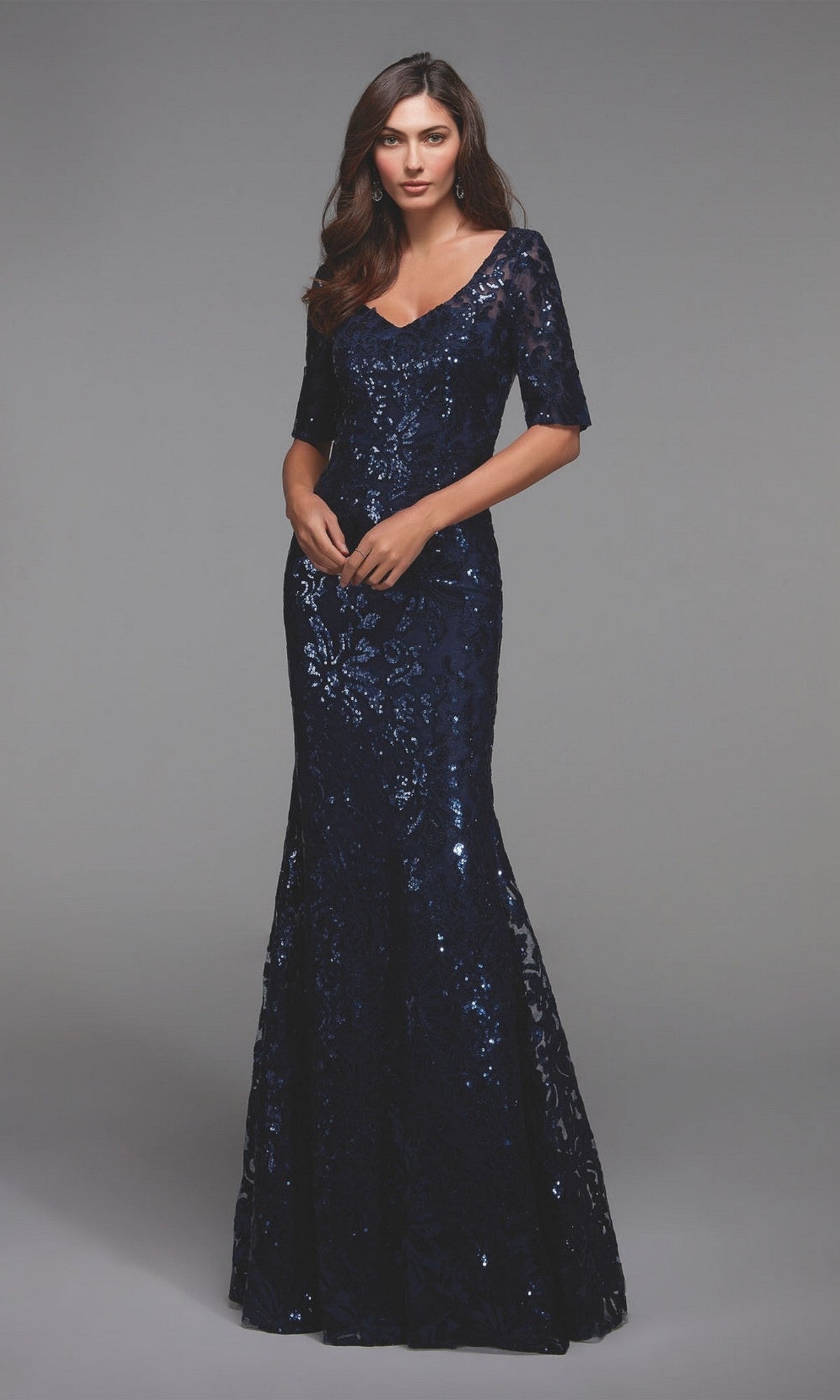A woman wears the Alyce 27497 long formal dress, a navy blue sequin evening gown with short sleeves and a fitted bodice, perfect as a mother-of-the-bride dress, set against a plain gray background.