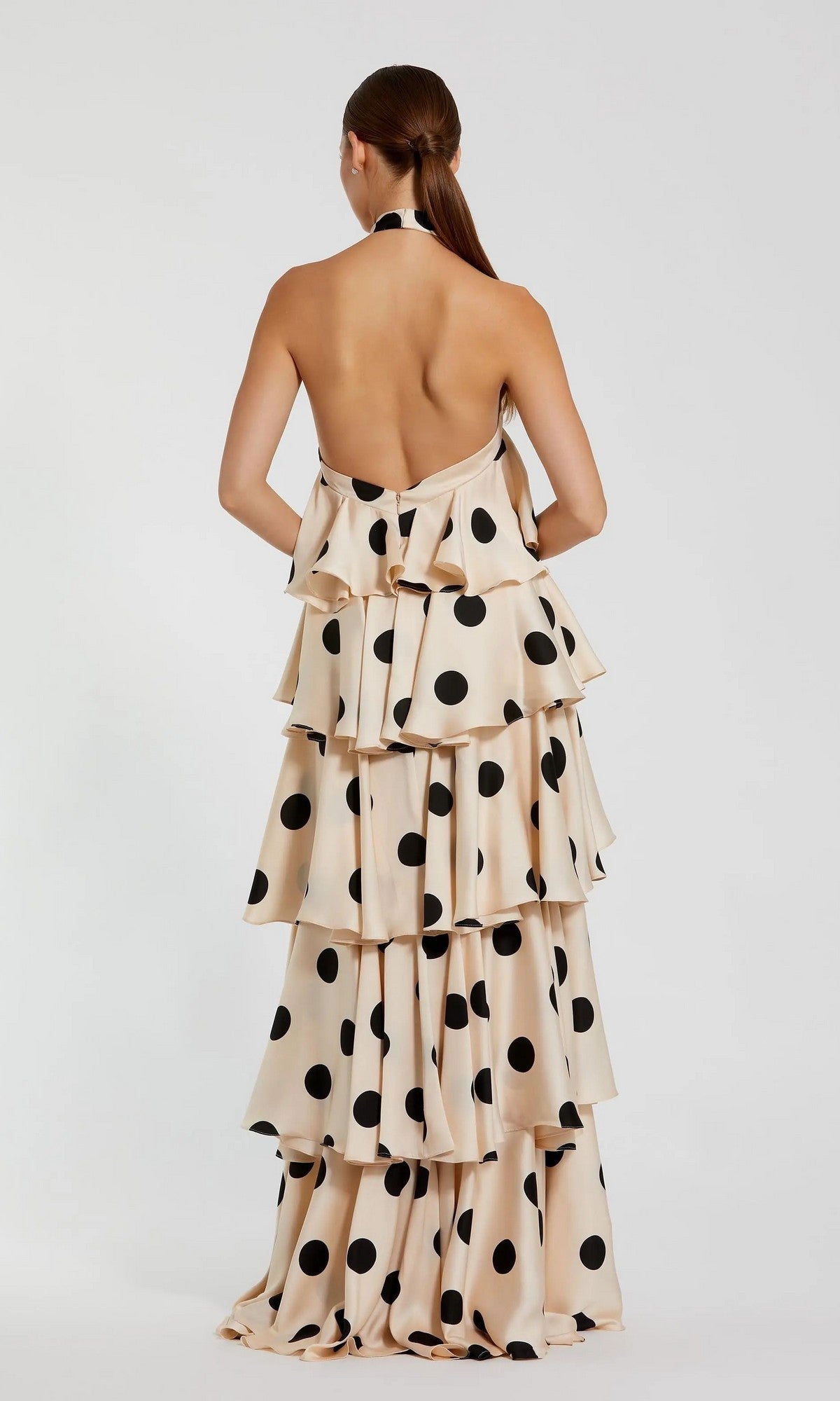 Back view of a cream, floor-length Mac Duggal 27540 halter dress with large black polka dots and a ruffle tiered silhouette.