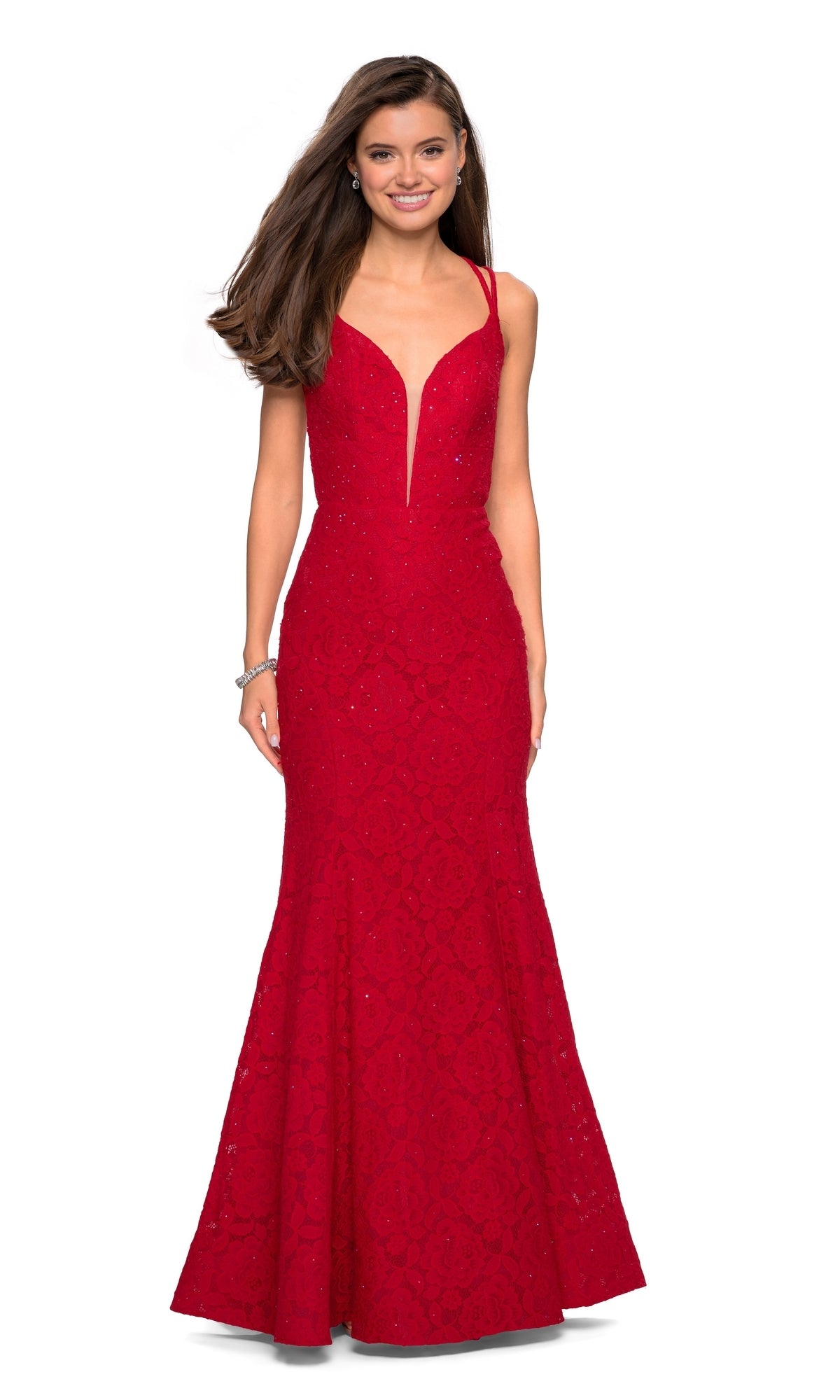 A woman stands smiling against a white background, wearing the La Femme 27560 backless lace mermaid prom dress with a sleeveless design and deep V-neckline.