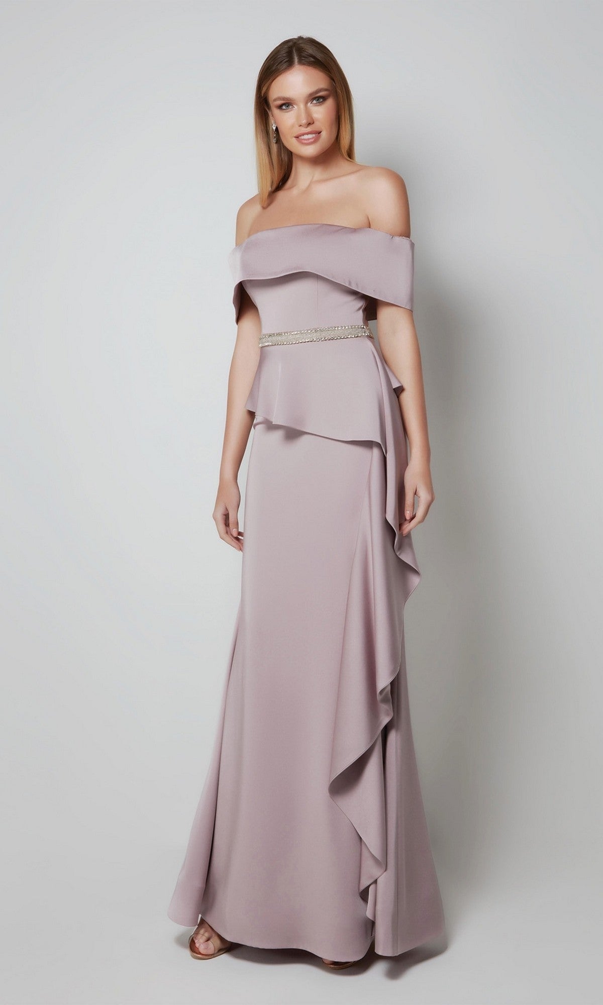 A woman poses against a plain background in the Alyce 27563 long formal dress, an off-the-shoulder mauve gown with ruffle details and a beaded belt—an elegant option for a mother-of-the-bride.