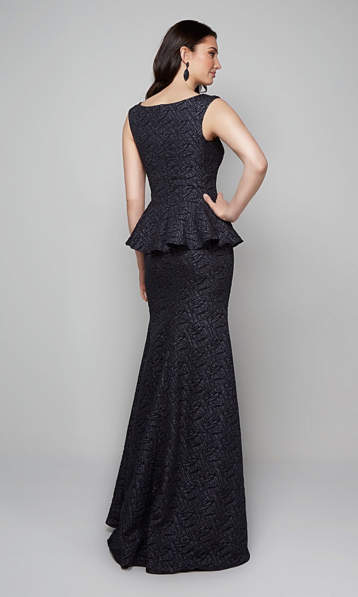 A woman faces away, wearing the Alyce 27579 long formal dress, featuring textured jacquard fabric and a striking peplum waist detail.