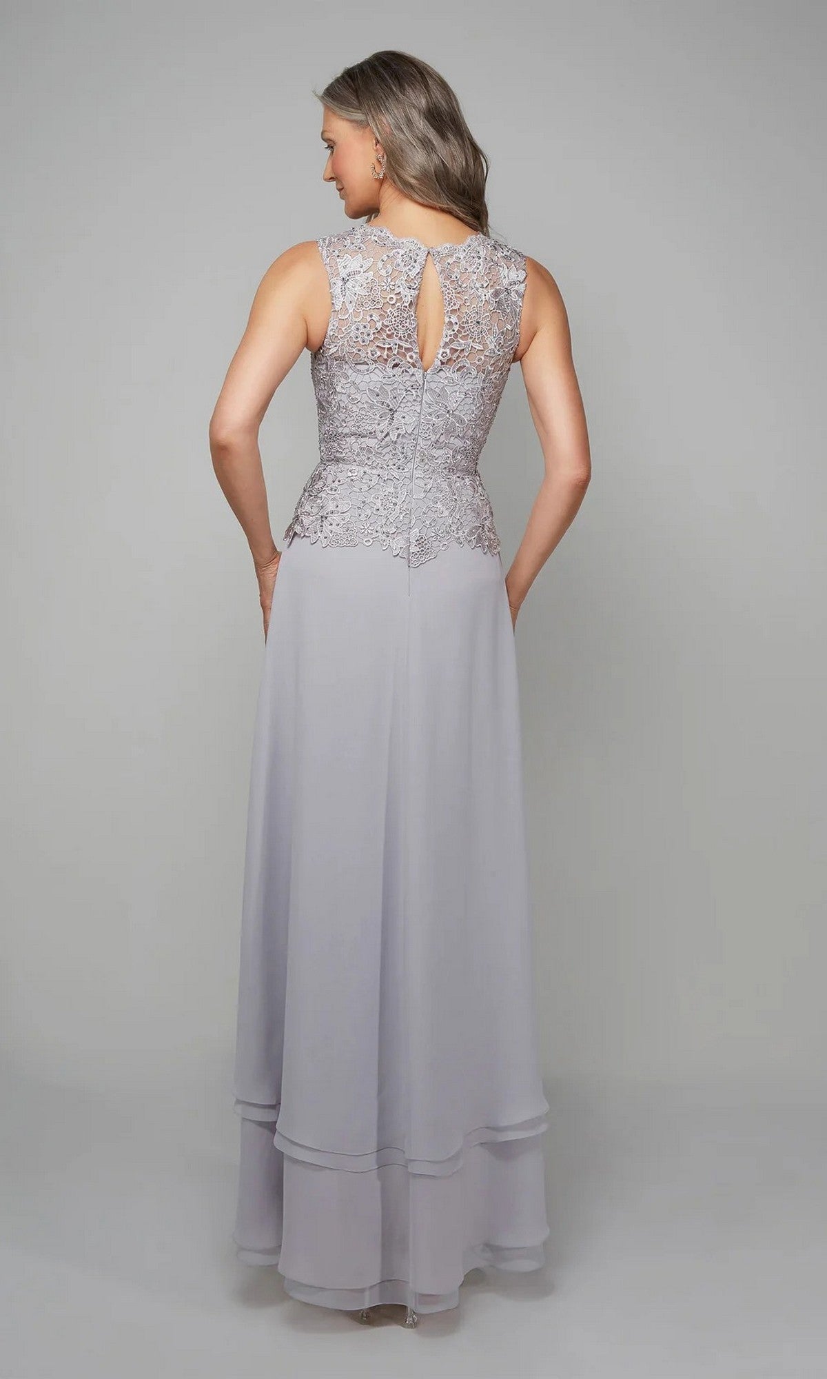 A woman faces away, wearing the Alyce 27608—an elegant lavender sleeveless gown with beaded lace bodice and layered chiffon skirt, perfect as a mother of the bride dress.