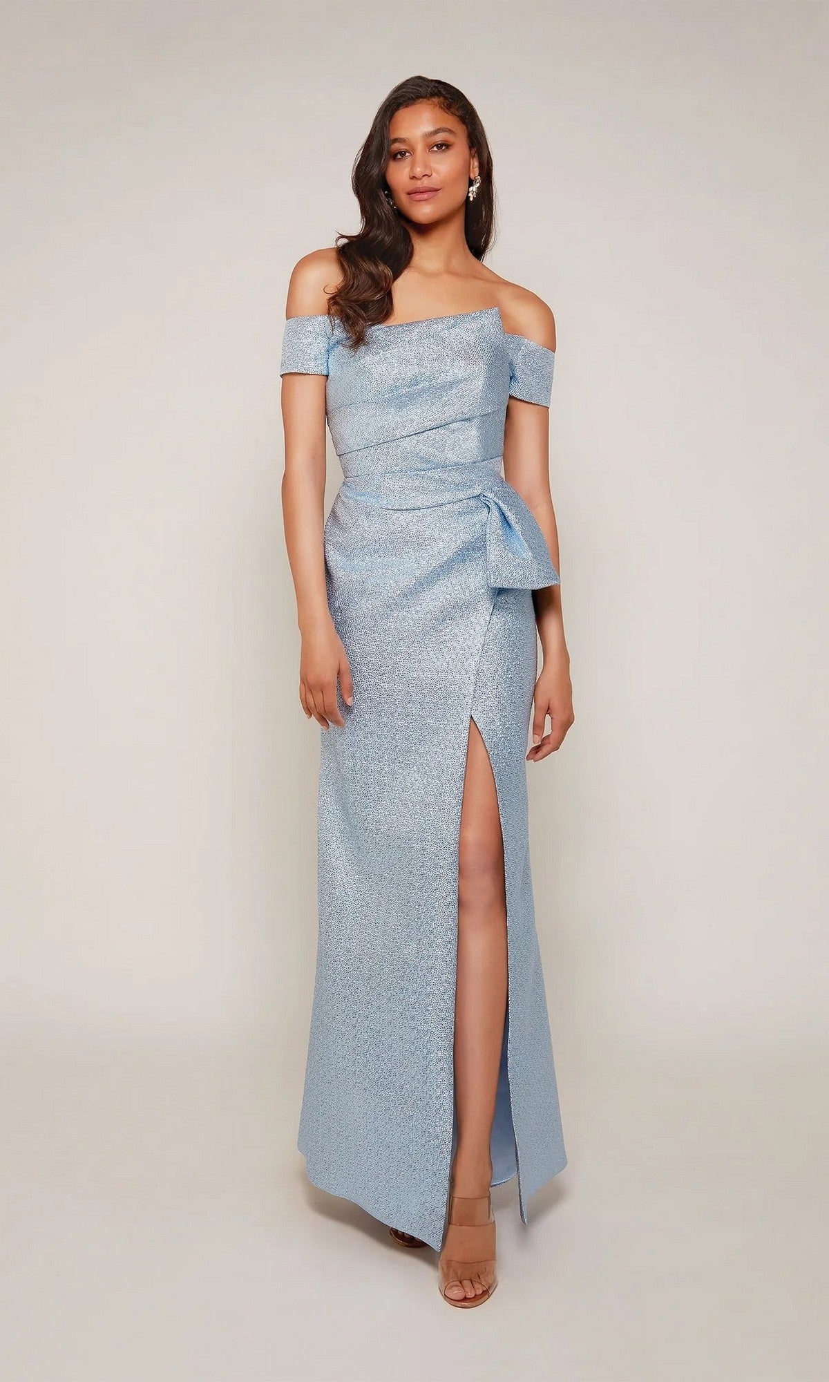 A woman models the Alyce 27639 long formal dress—an off-the-shoulder, light blue gown with a side slit and bow detail—against a plain background.